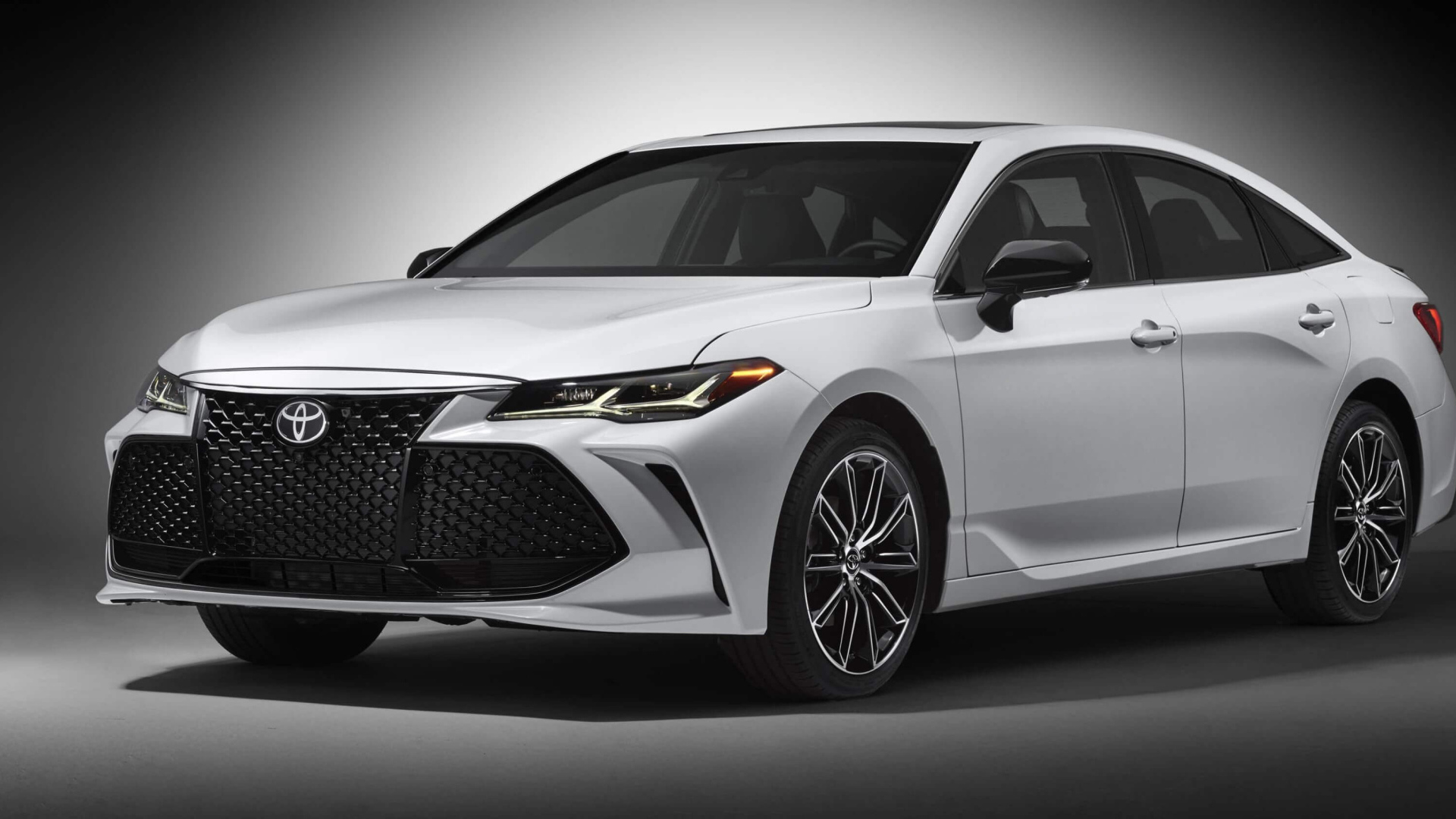 Белый автомобиль Toyota Avalon 2019 на сером фоне