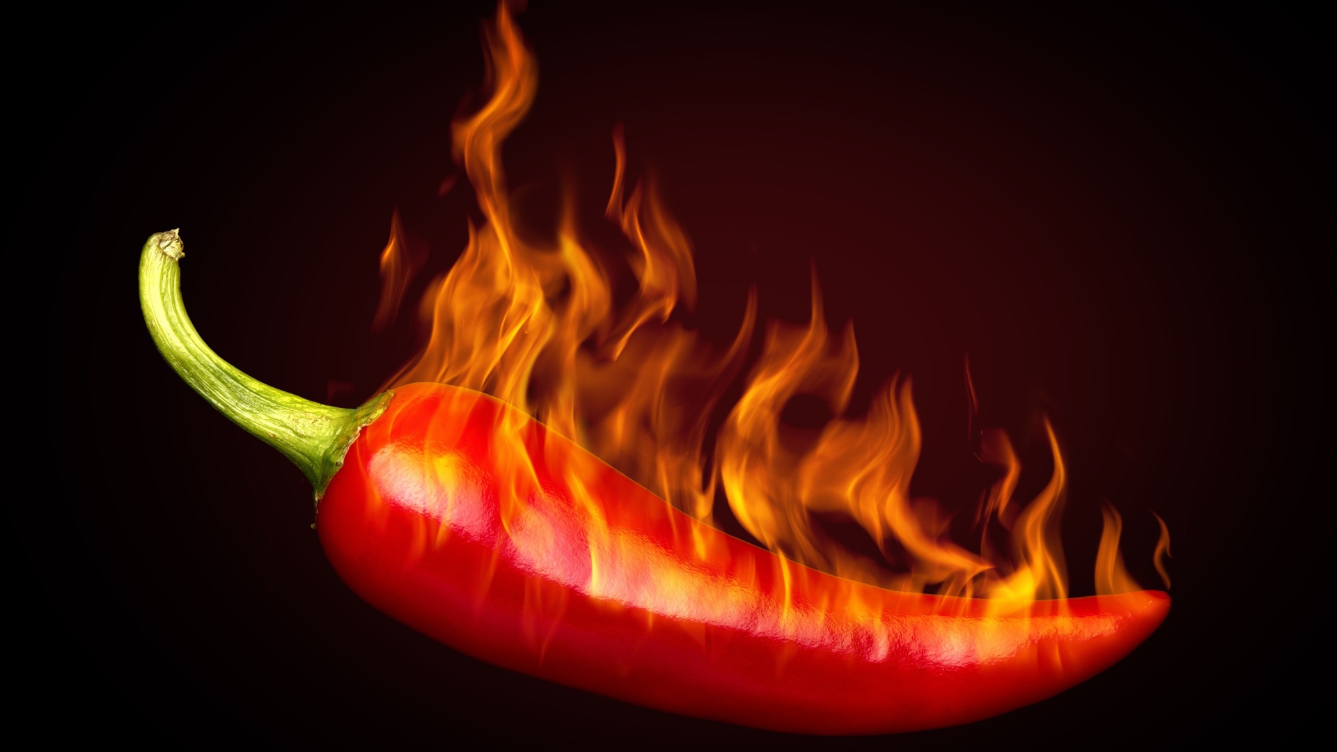 Красный перец с пламенем на черном фоне