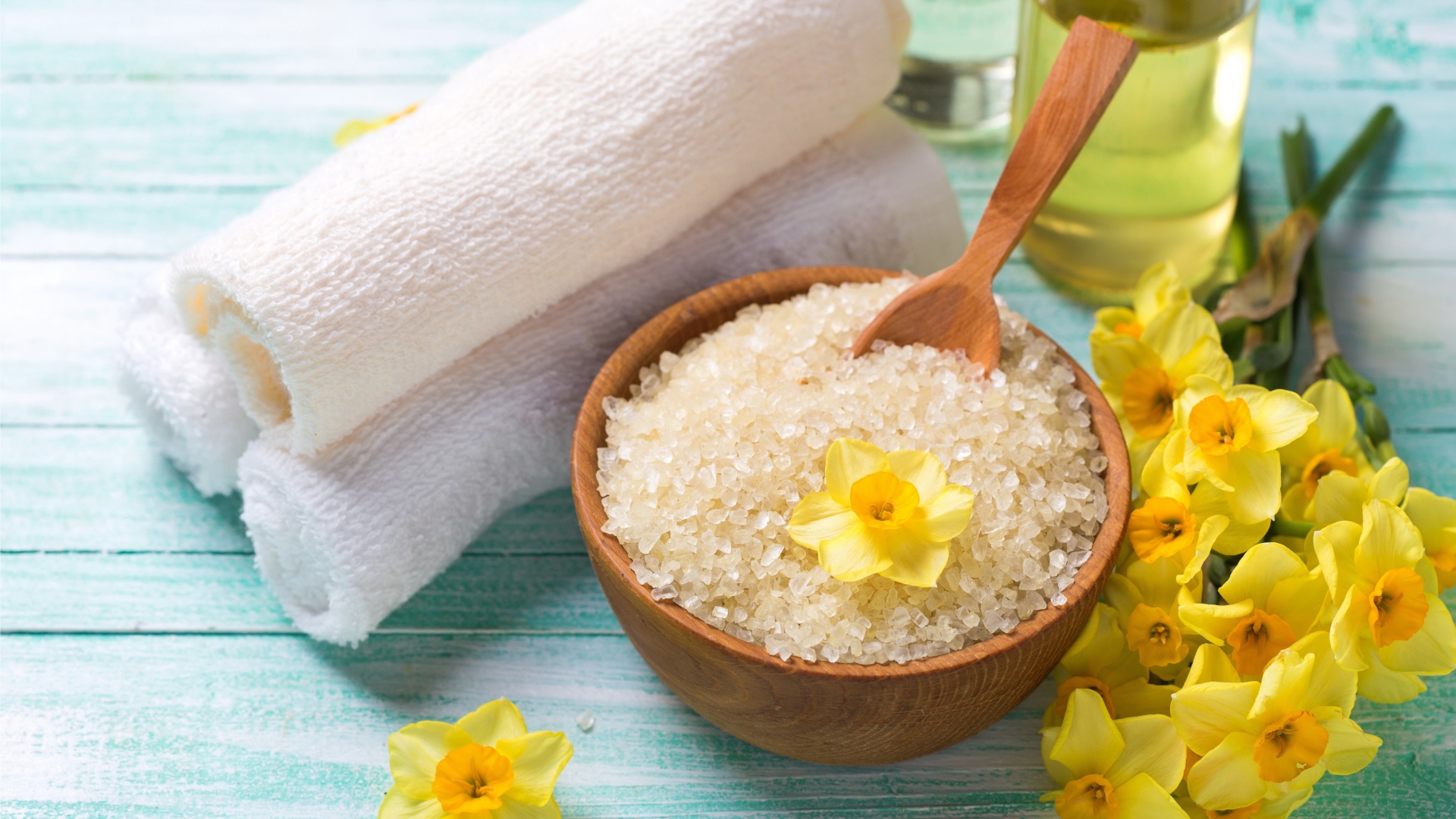 Соль с цветами нарцисса и полотенцем на столе