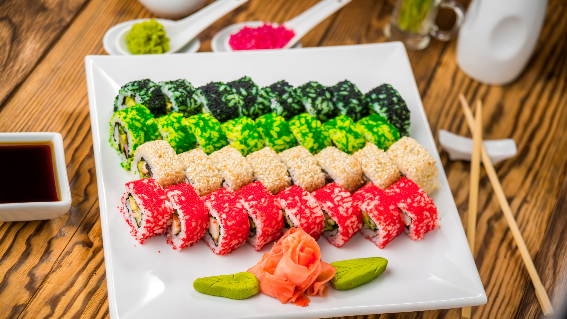 Аппетитные роллы с имбирем и соусом васаби на белой тарелке 