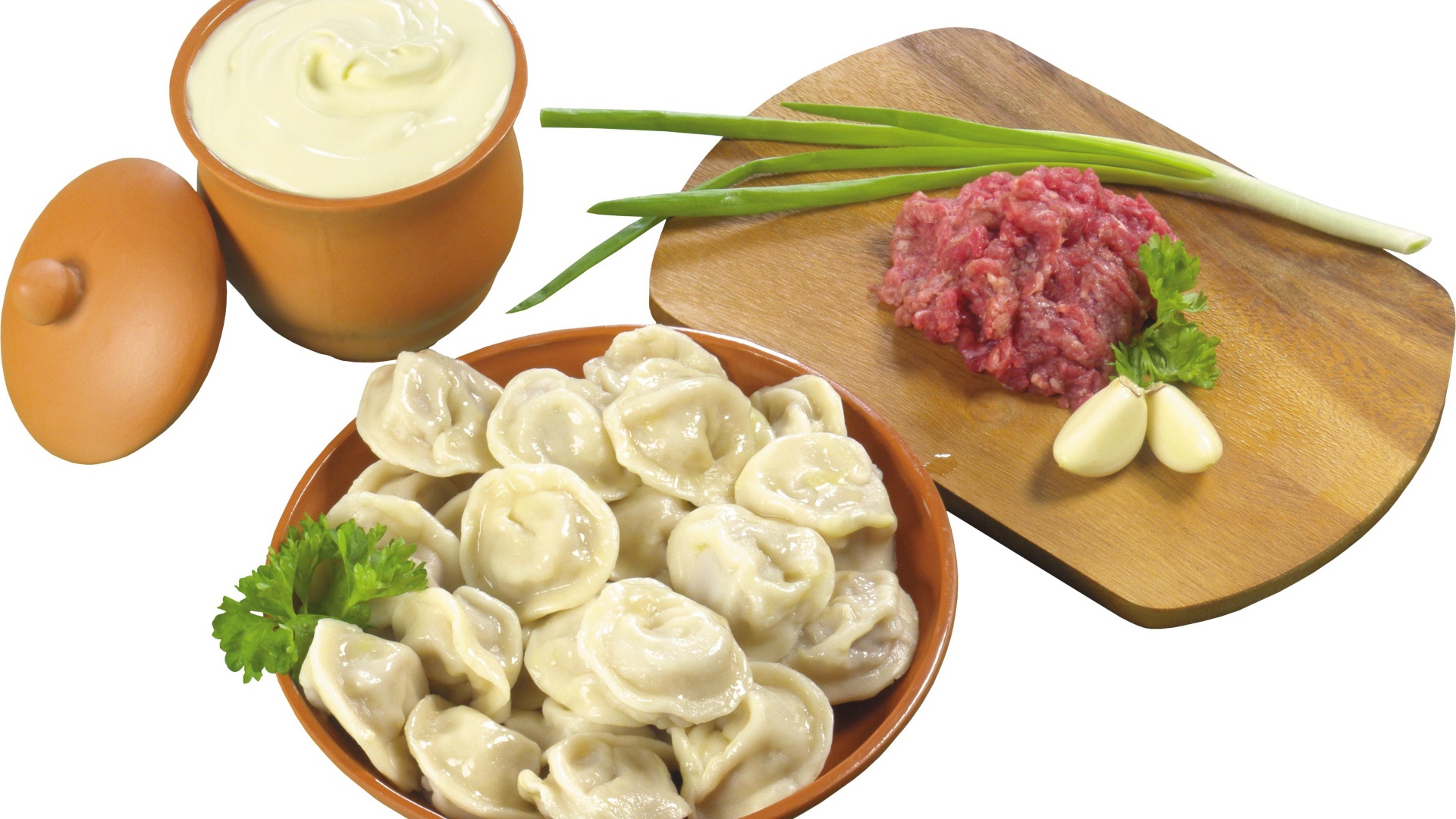 Boiled dumplings on the table with minced meat, sour cream and green onions