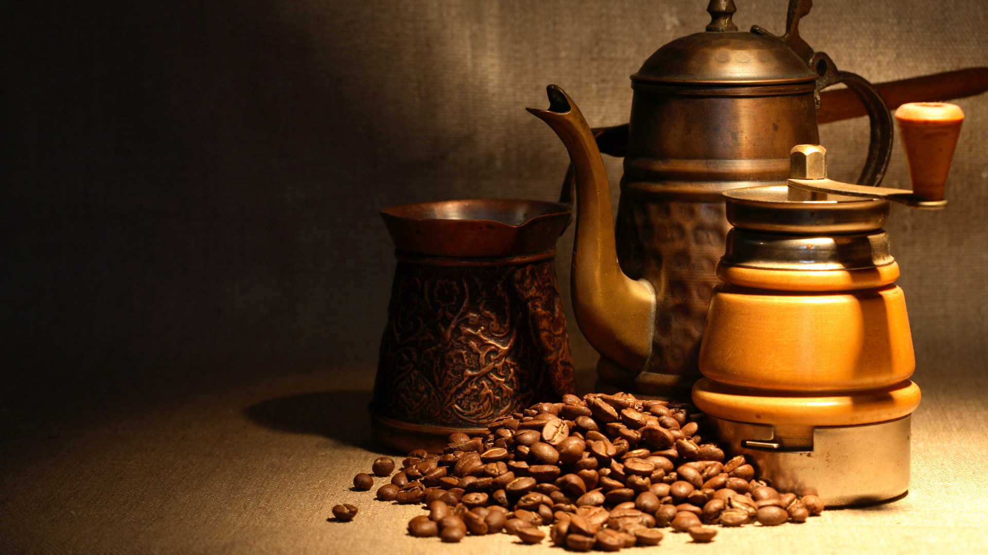 Кофемолка, турка, чайник и кофейные зерна на столе