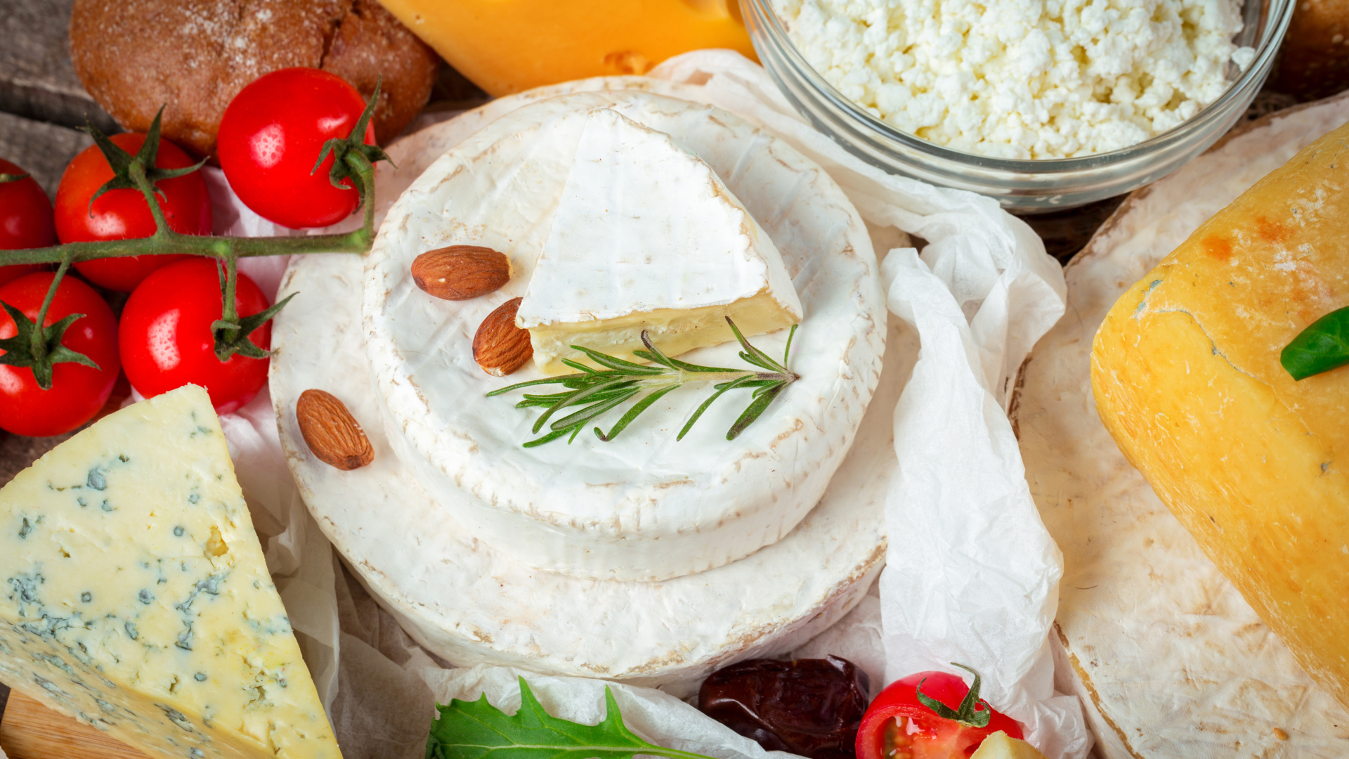 Разные виды сыра на столе с помидорами 