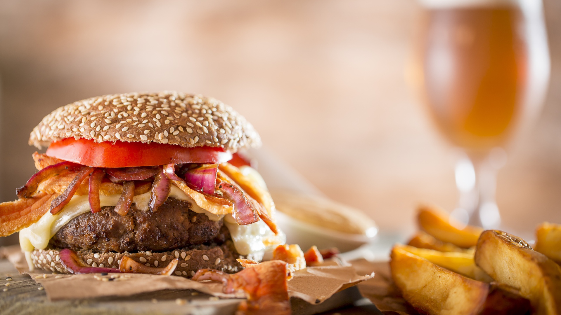 Гамбургер на столе с картофелем и бокалом пива