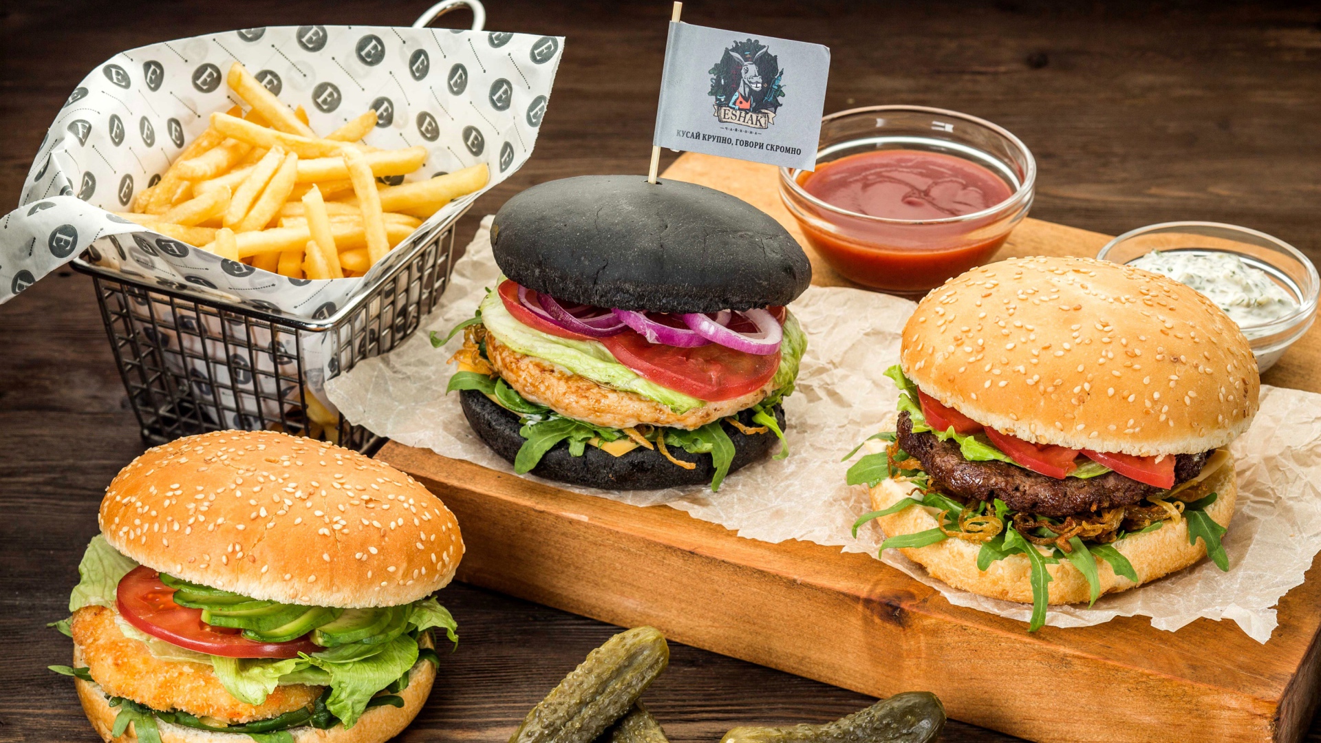 Гамбургеры с картофелем фри и солеными огурцами на столе 