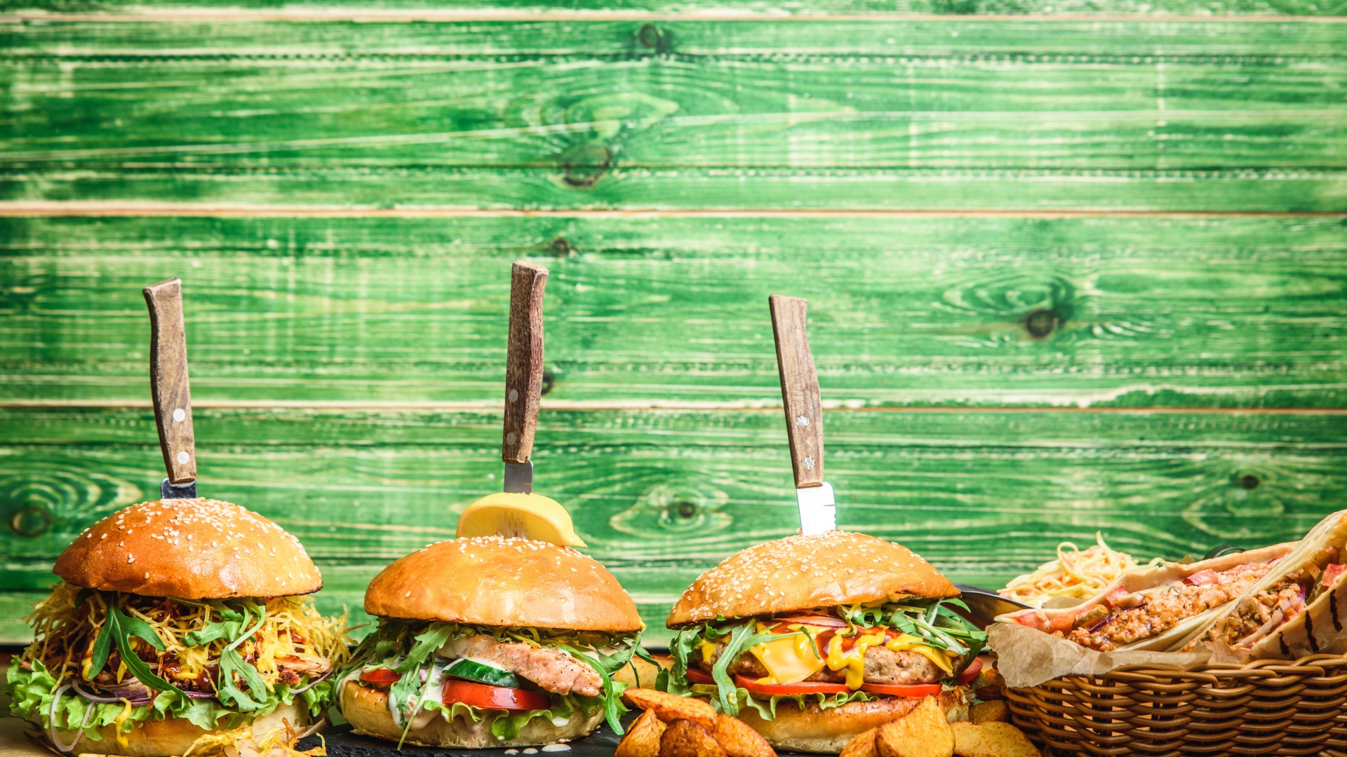 Гамбургеры с ножами на деревянном фоне