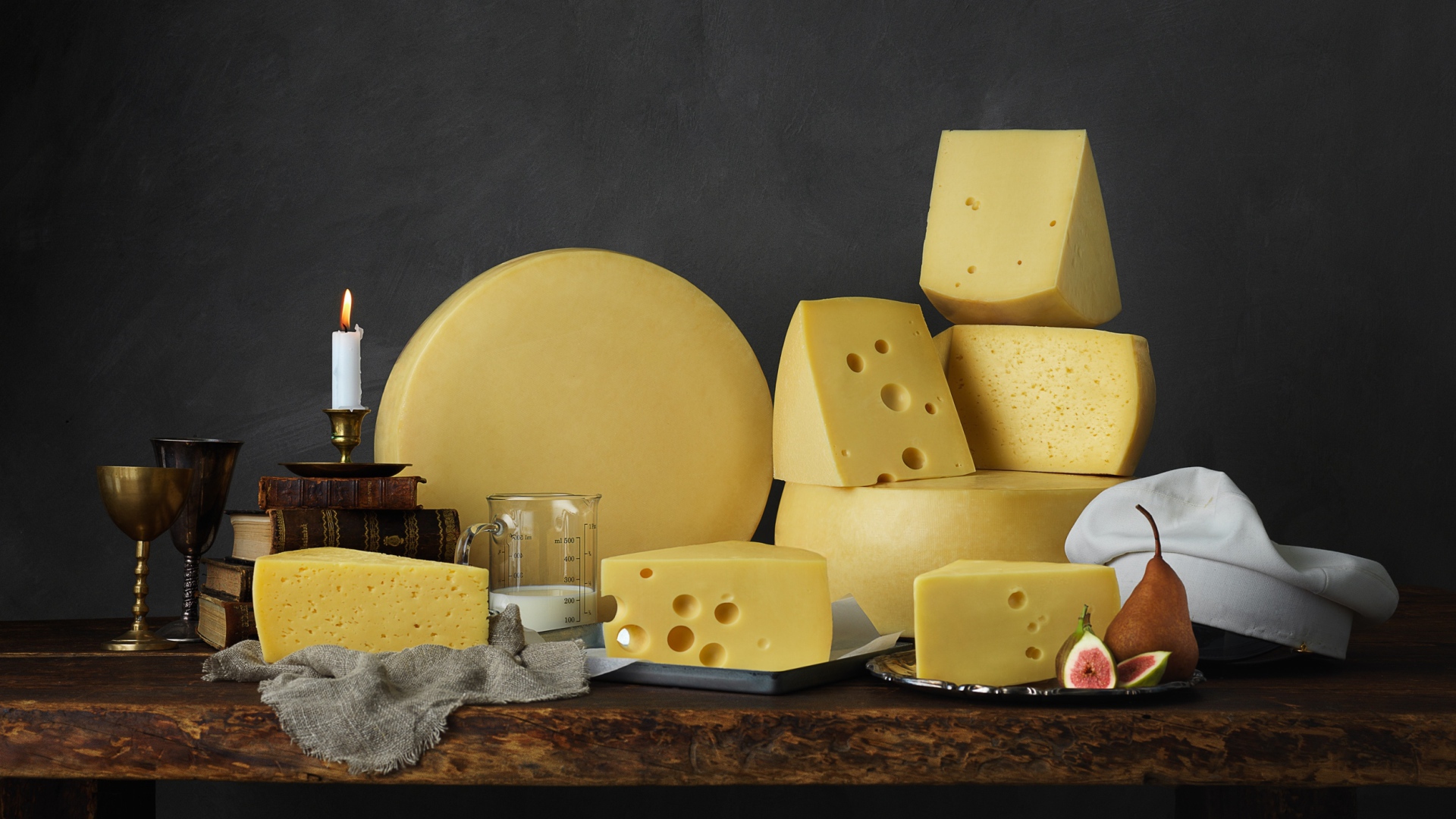 Твердый сыр на столе с книгами 