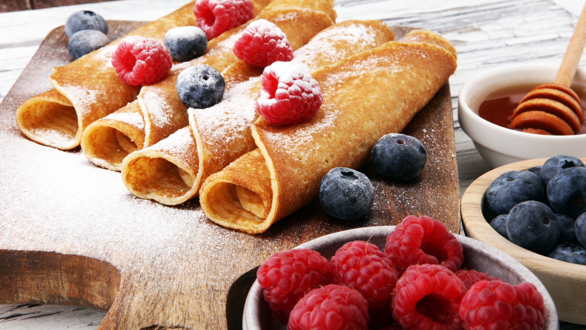 Блинчики с ягодами черники, малиной и сахарной пудрой