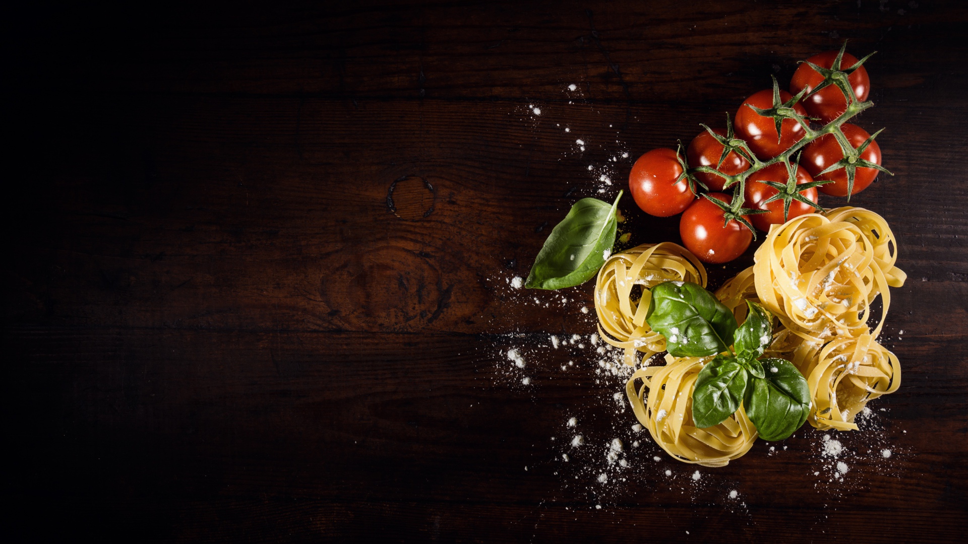 Паста с помидорами и листьями базилика на столе