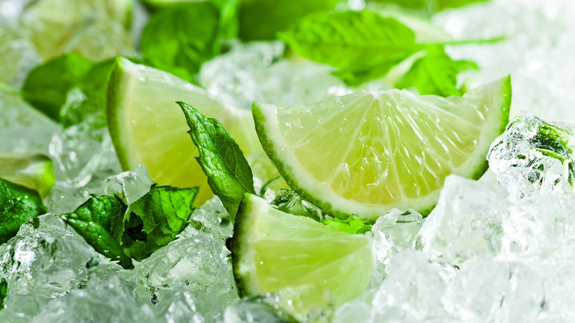 Pieces of fresh lime with mint leaves lie on ice