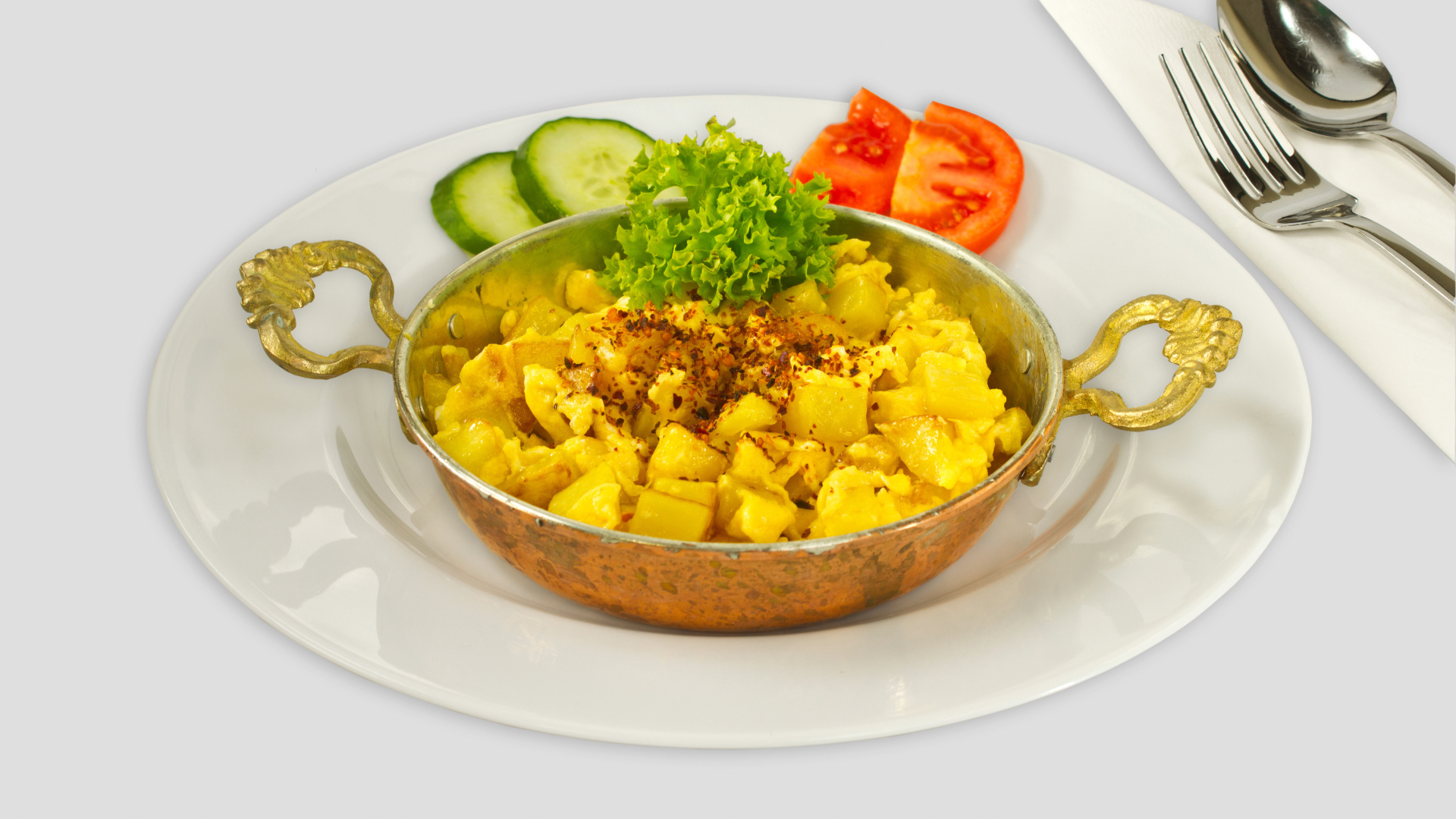 Картофель с овощами на белой тарелке