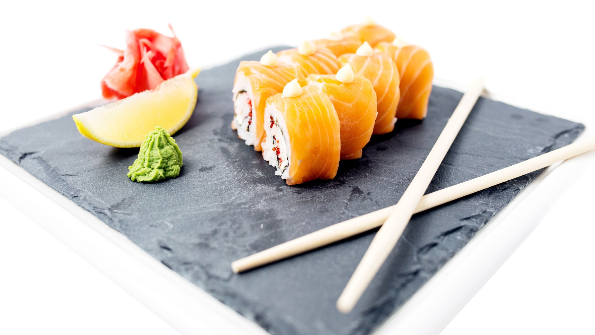 Роллы с красной рыбой на тарелке с палочками