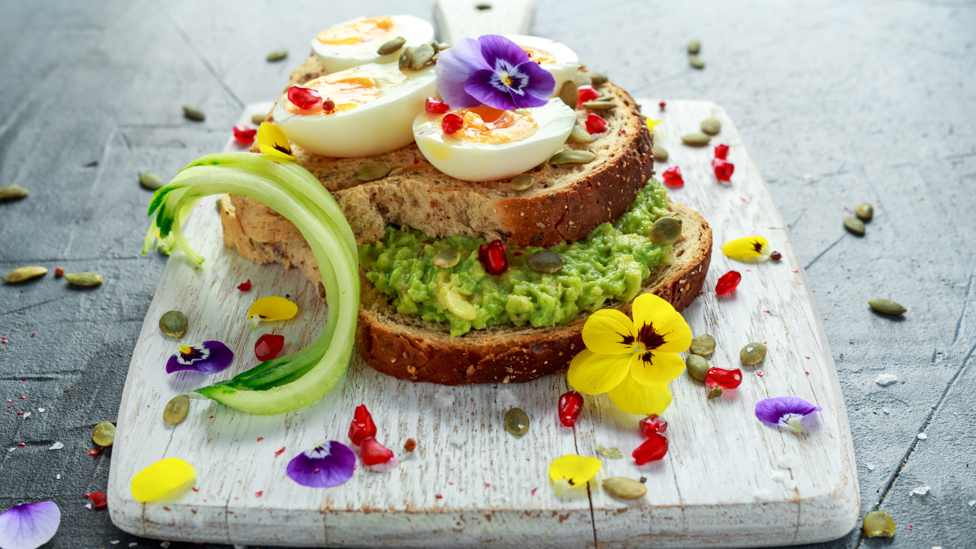 Сендвич с яйцом и цветами на доске