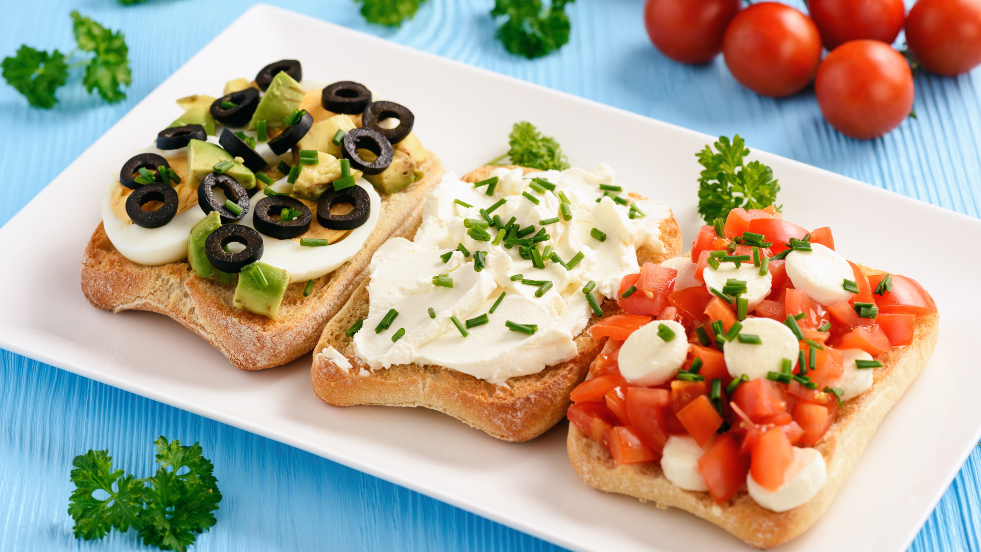 Три аппетитных бутерброда на столе с помидорами и петрушкой