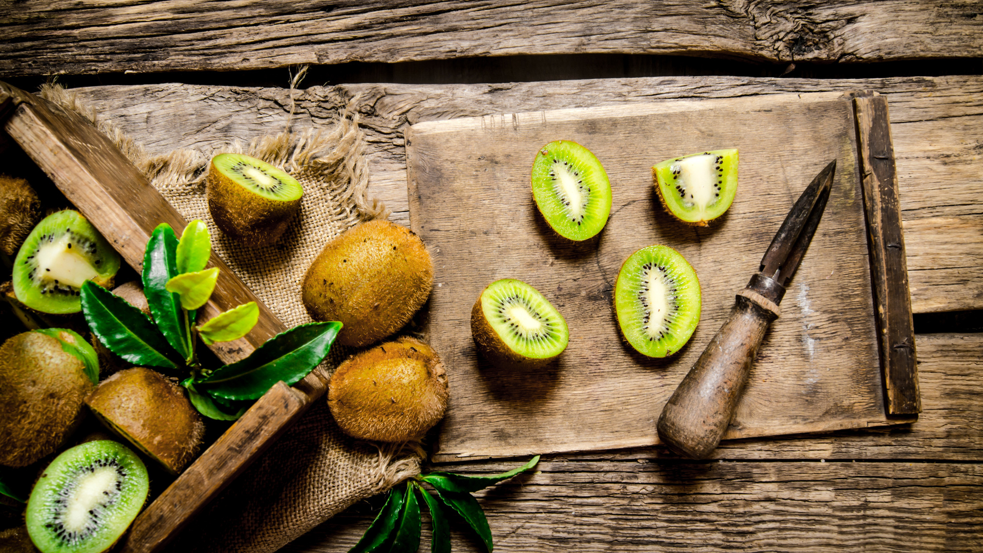 Нарезанное киви на разделочной доске с ножом