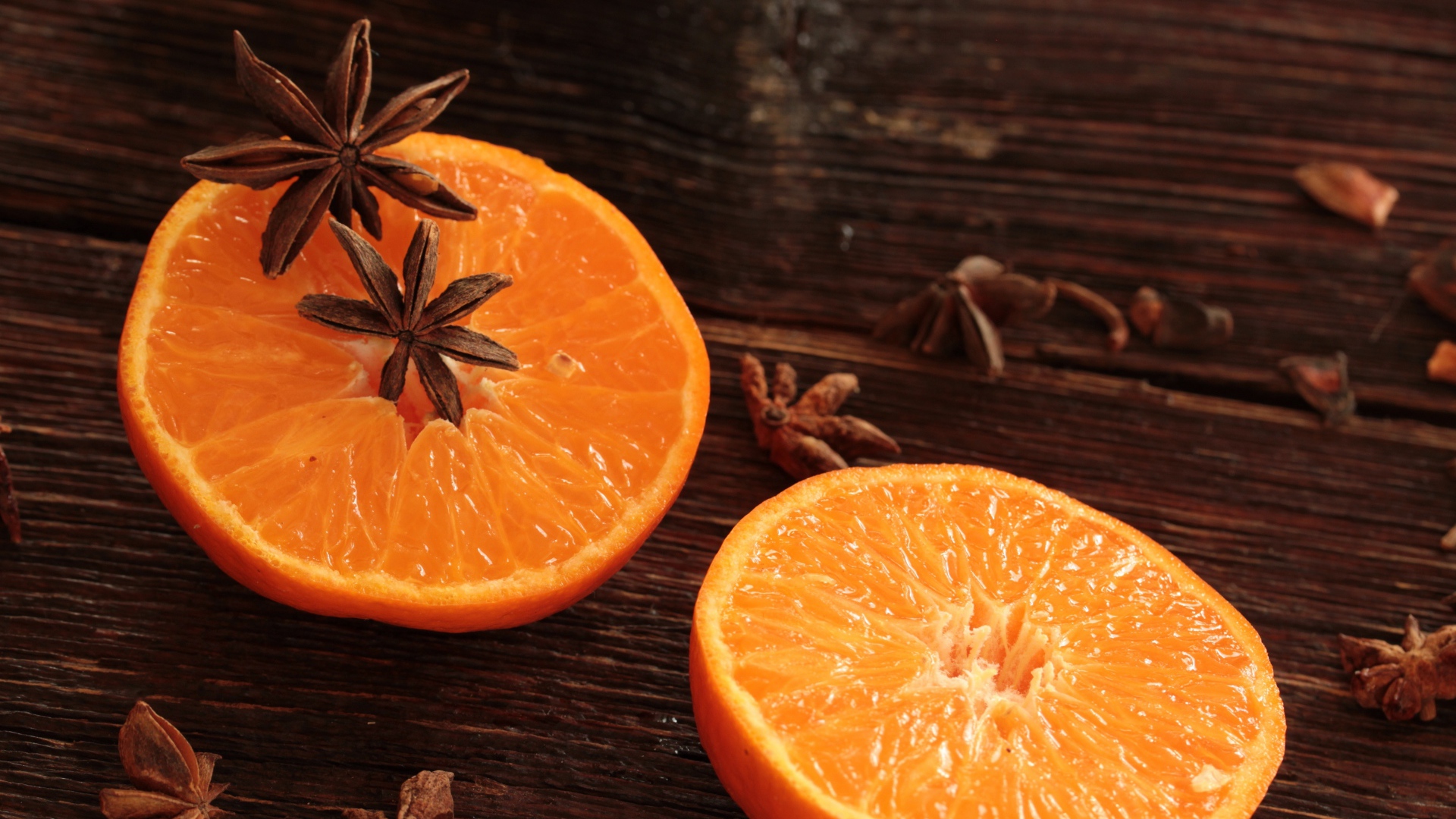 Две половины апельсина на деревянном столе с бадьяном