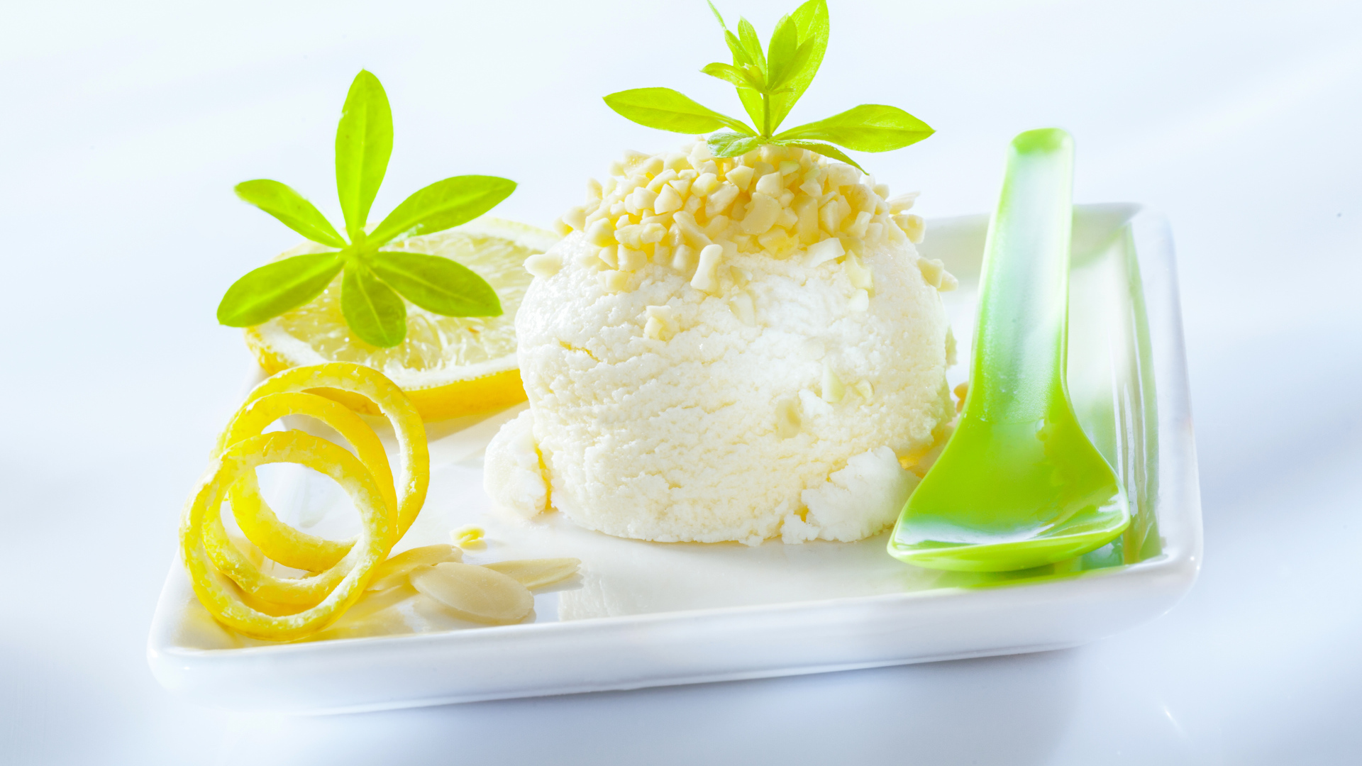 Шарик лимонного мороженого с фисташками с зеленой ложкой