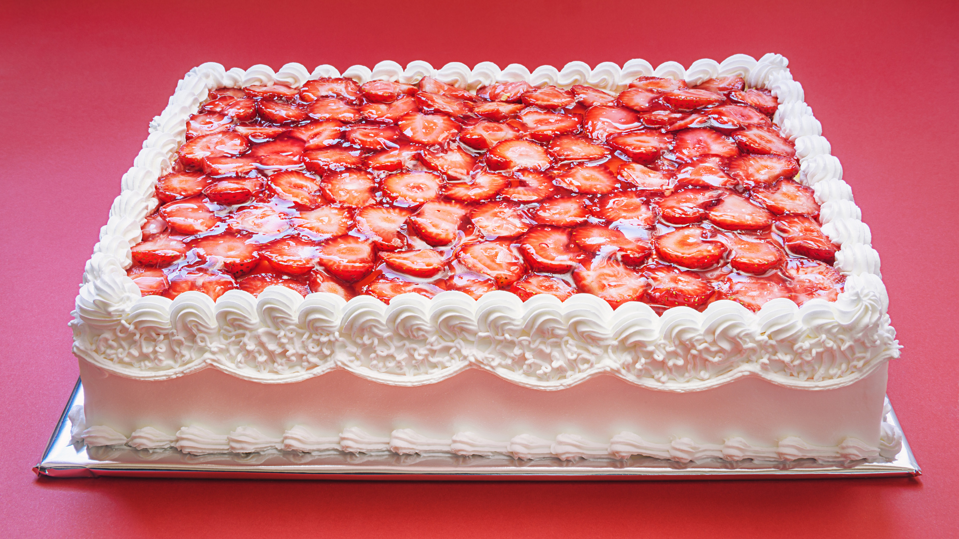 Большой праздничный торт с белым кремом и клубникой