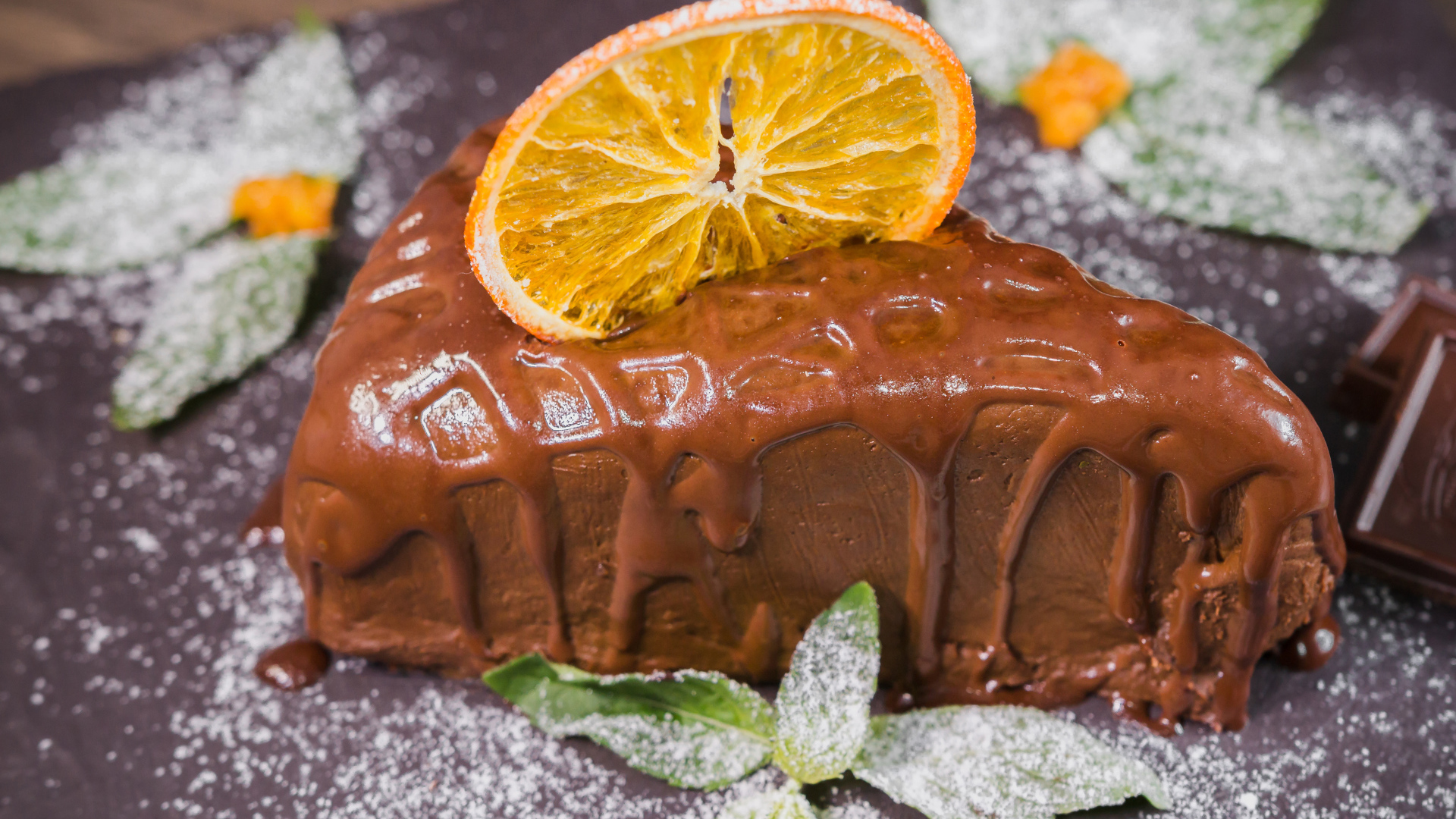 Кусок пирожного с шоколадом и кусочком апельсина