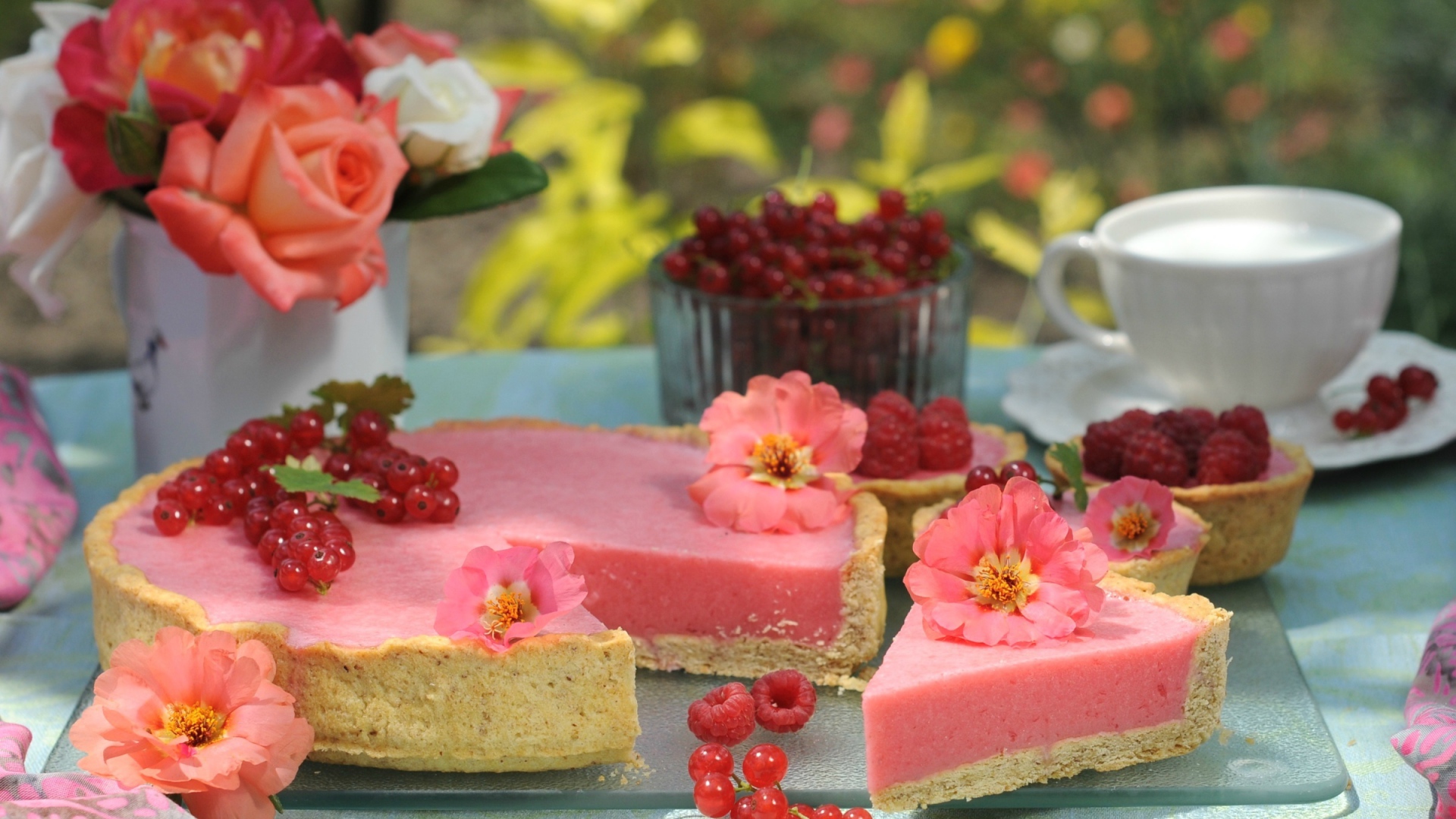 Аппетитный пирог с ягодами малины и красной смородины на столе с цветами