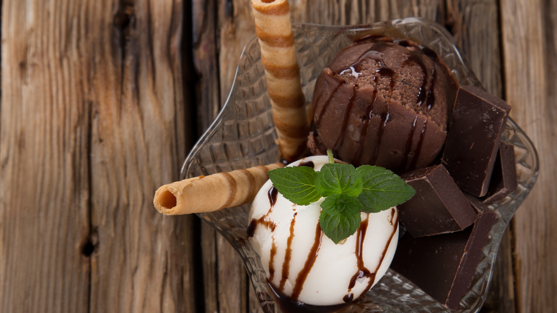 Шарик сливочного и шоколадного мороженого в пиале с трубочками