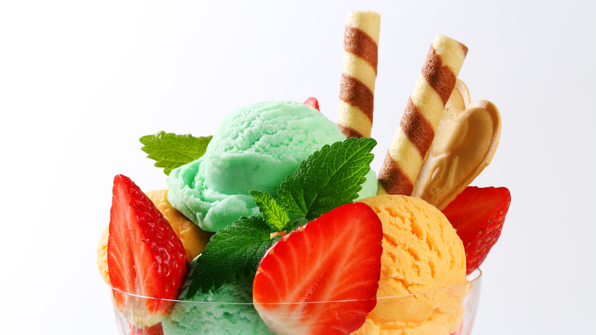 Шарики разноцветного мороженого с клубникой и трубочками