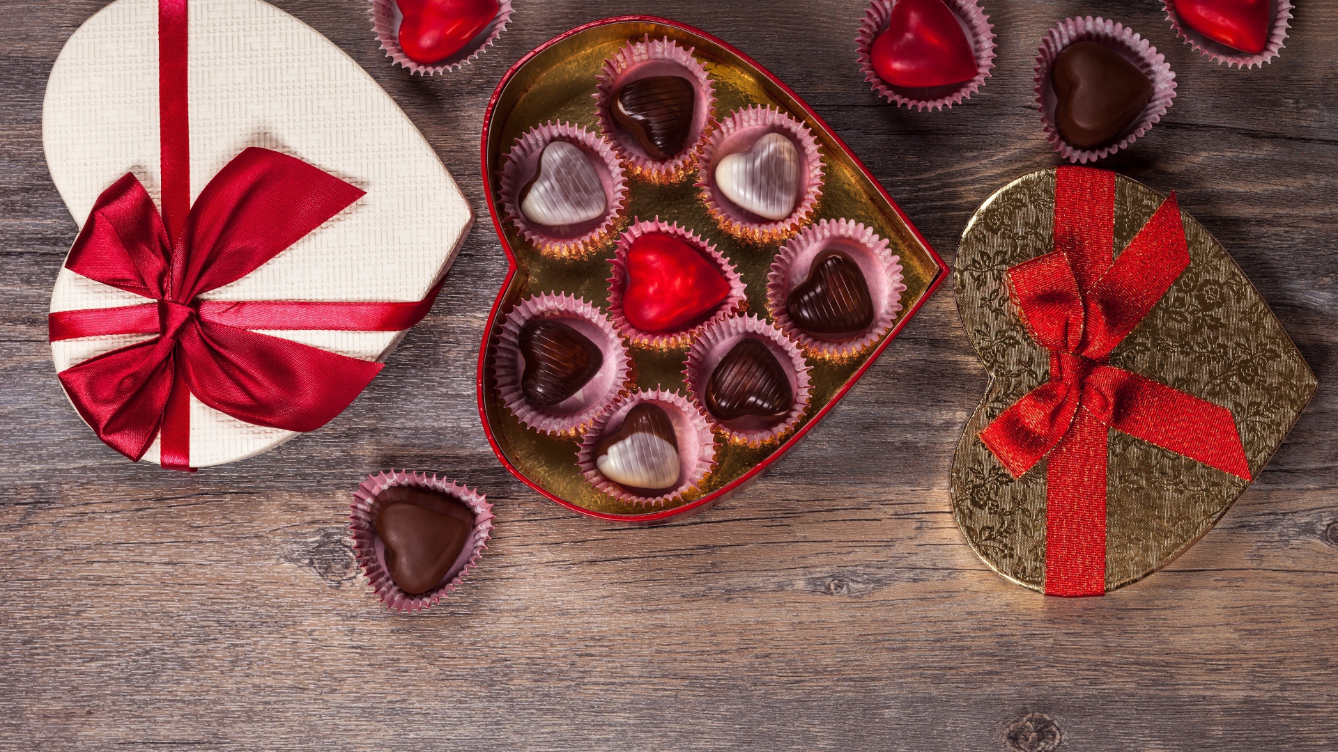 Коробки с шоколадными конфетами в форме сердца на столе 