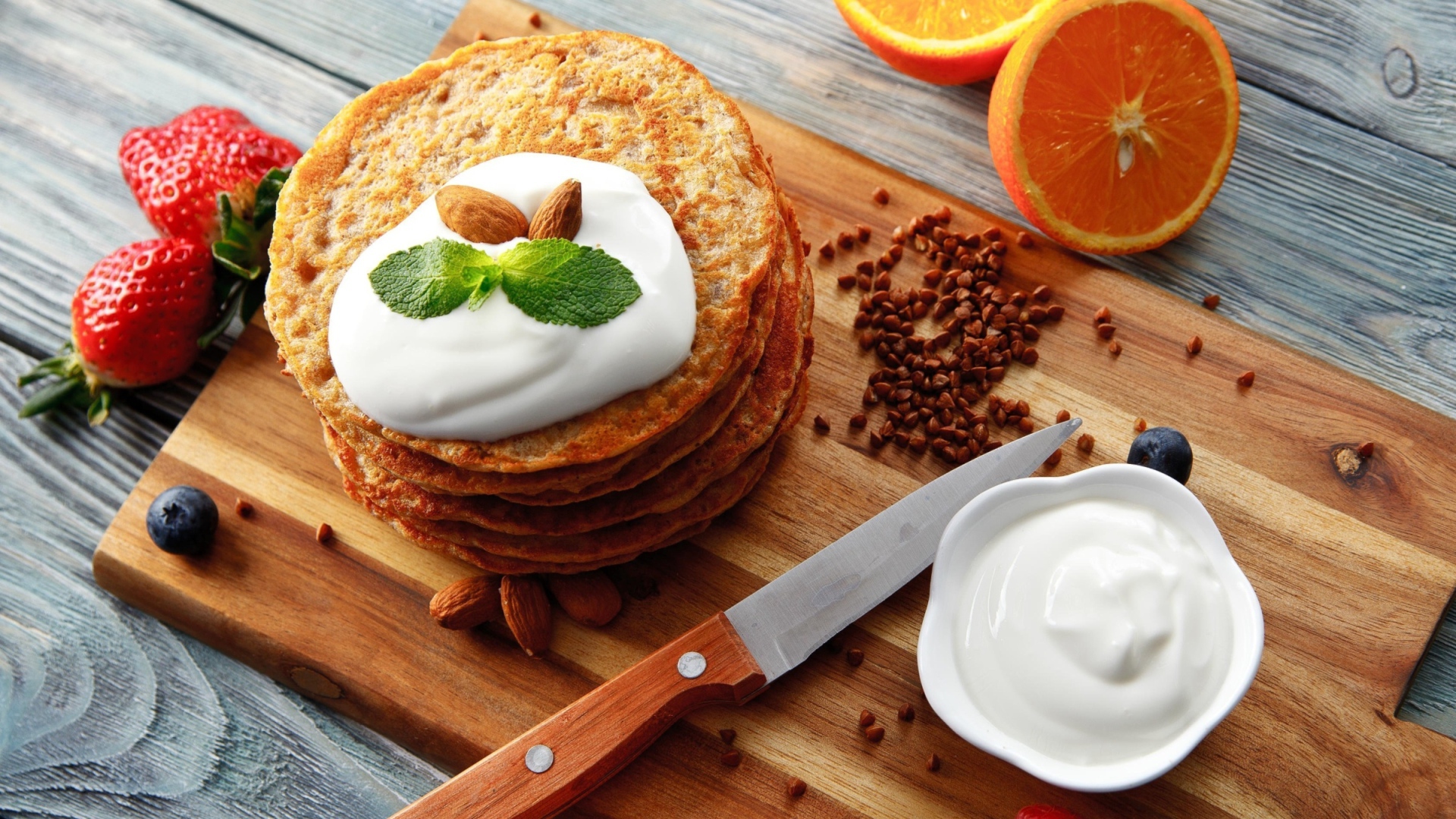 Гречневые оладьи со сметаной на разделочной доске