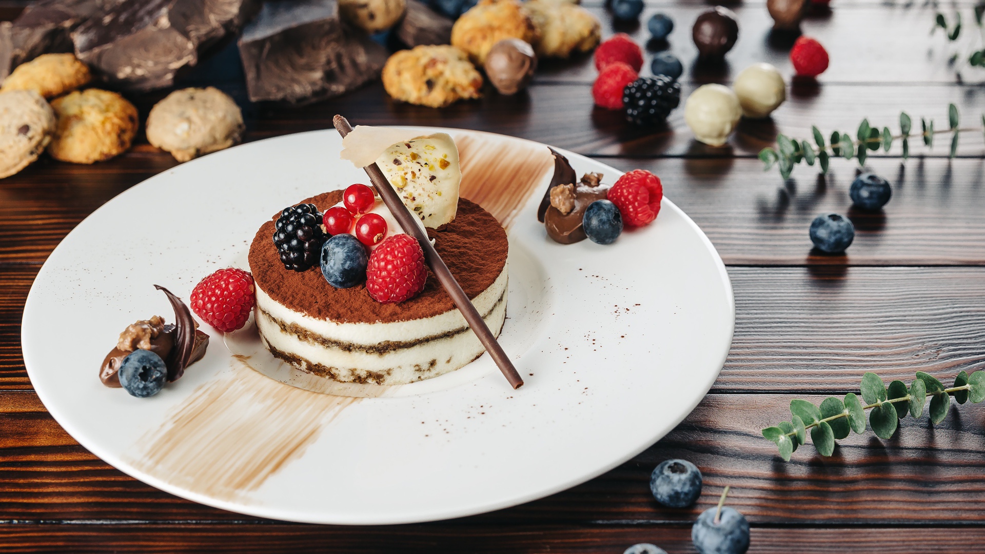 Пирожное с ягодами и шоколадом на белой тарелке 