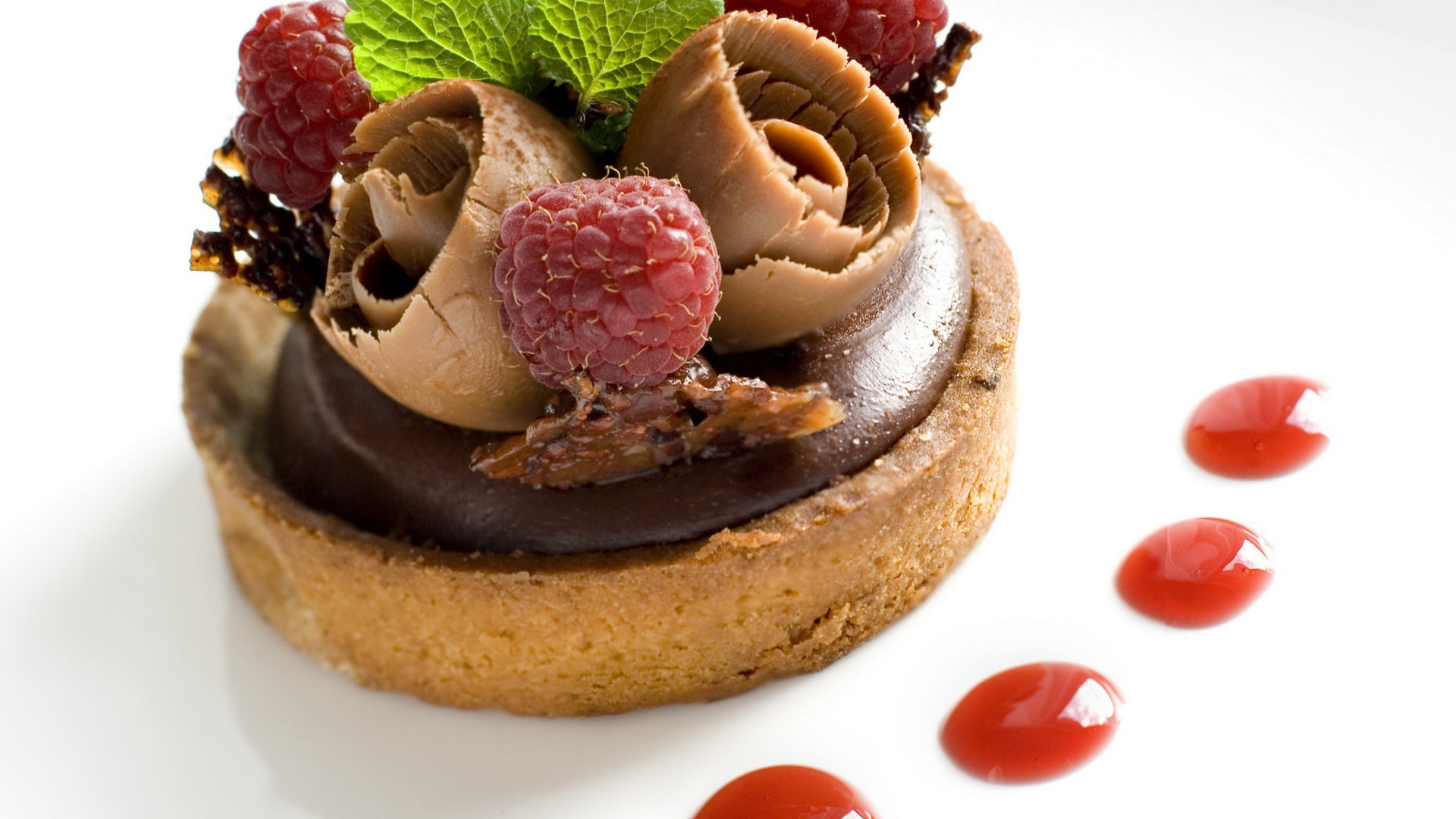 Пирожное с шоколадом и ягодами малины на белом фоне