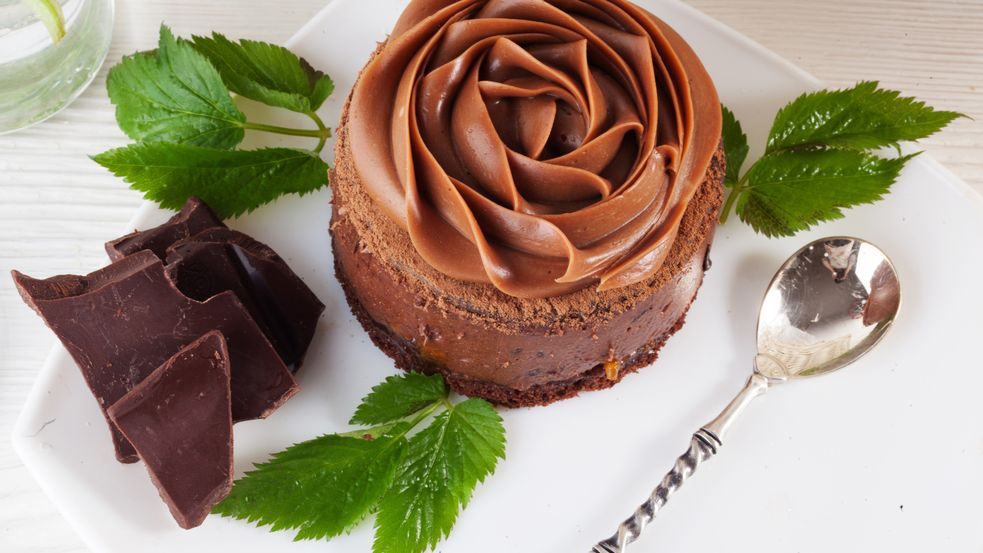 Пирожное с шоколадной кремовой розой на тарелке