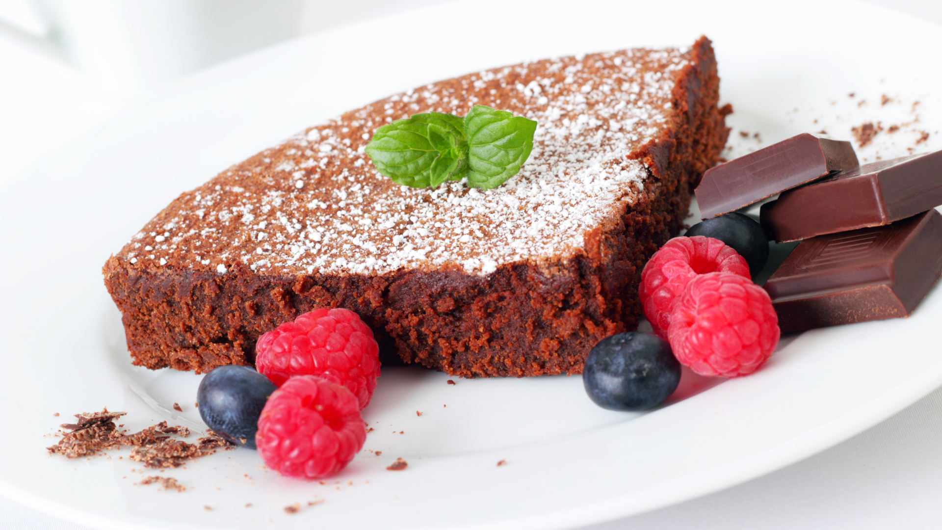 Шоколадный десерт брауни с ягодами малины и черники