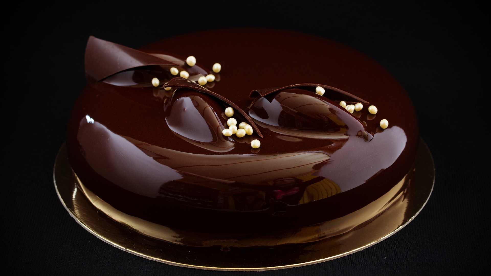 Шоколадный глянцевый торт на черном фоне 