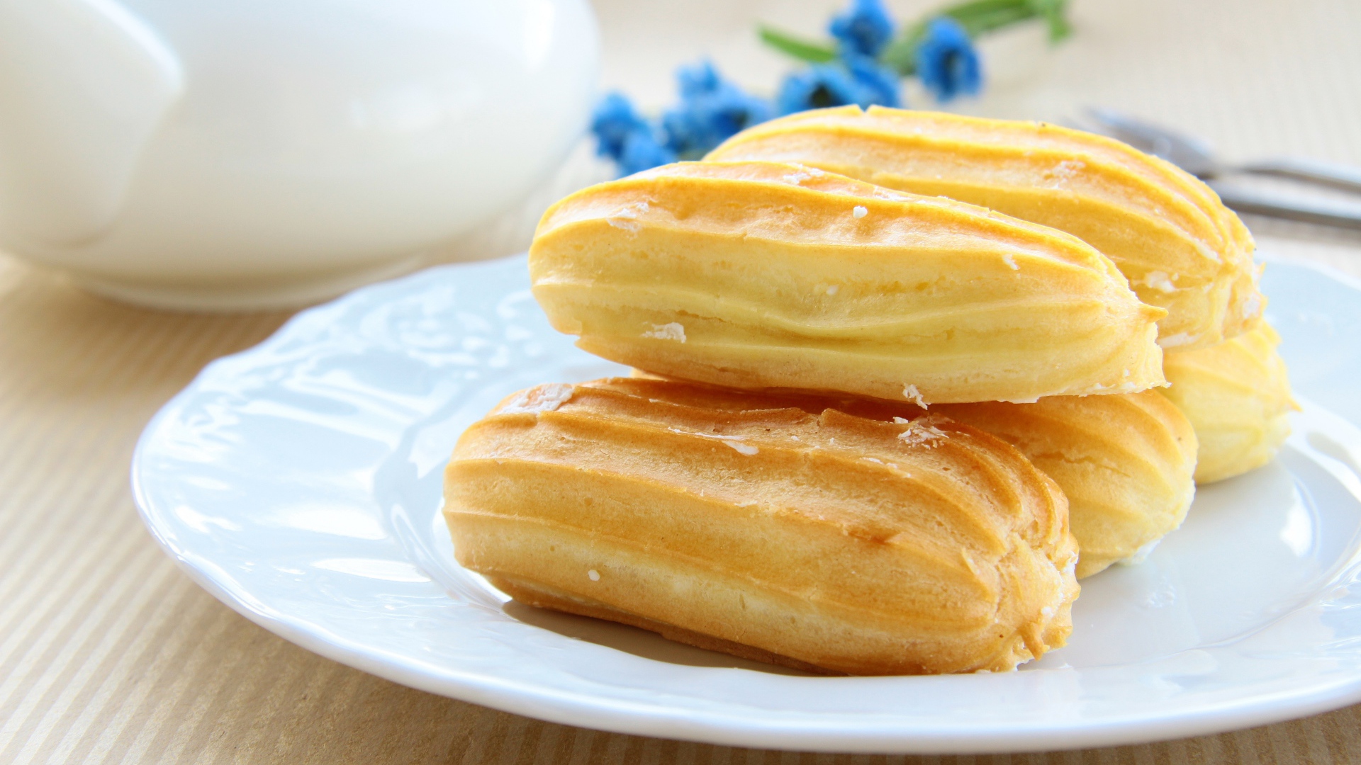 Заварные пирожные на большой белой тарелке 