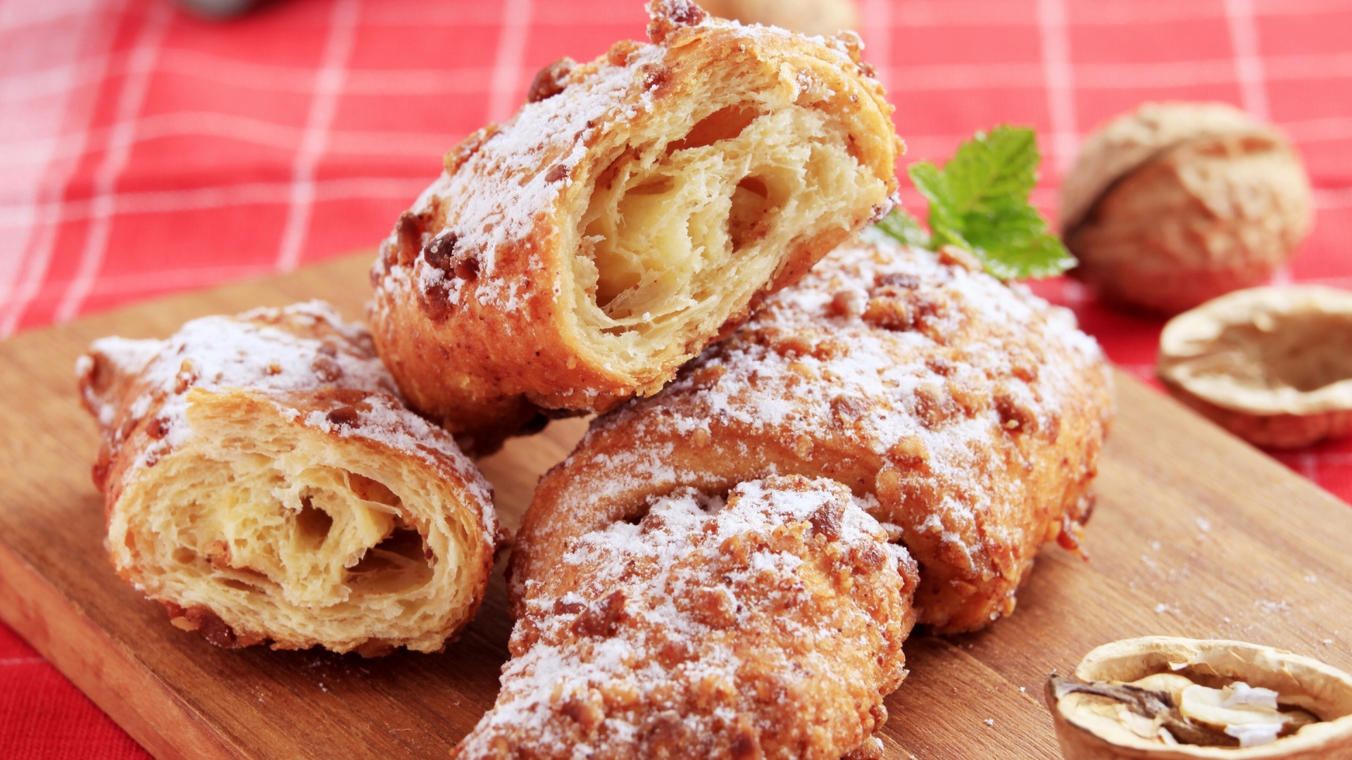 Круассаны с орехом и сахарной пудрой на разделочной доске