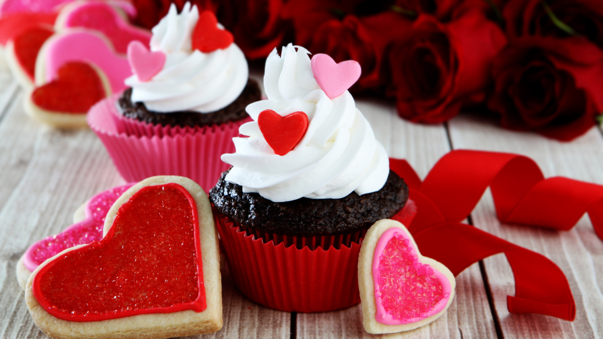 Капкейки с кремом и печенье в форме сердечек на столе