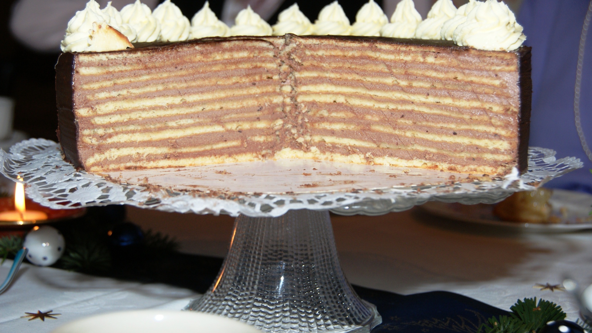 Разрезанный торт с кремом на стеклянном блюде