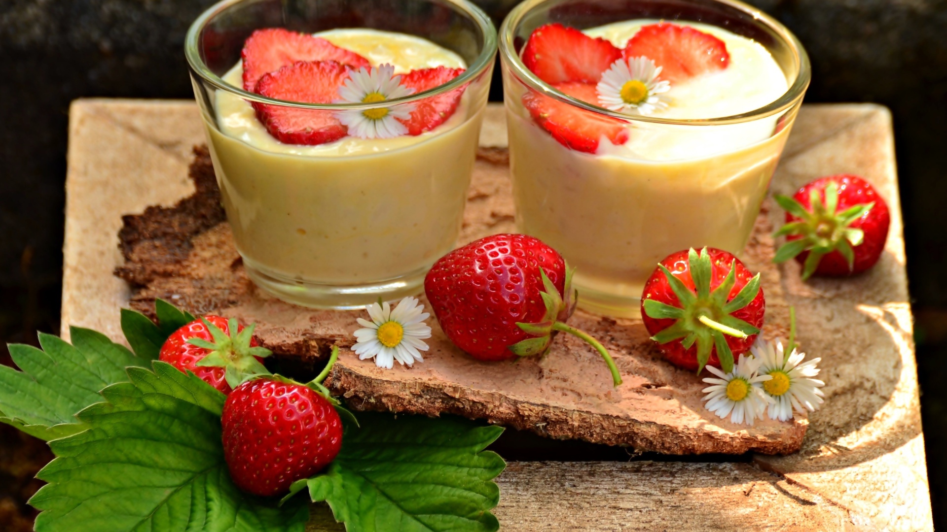 Десерт с йогуртом и свежей клубникой в стаканах на столе