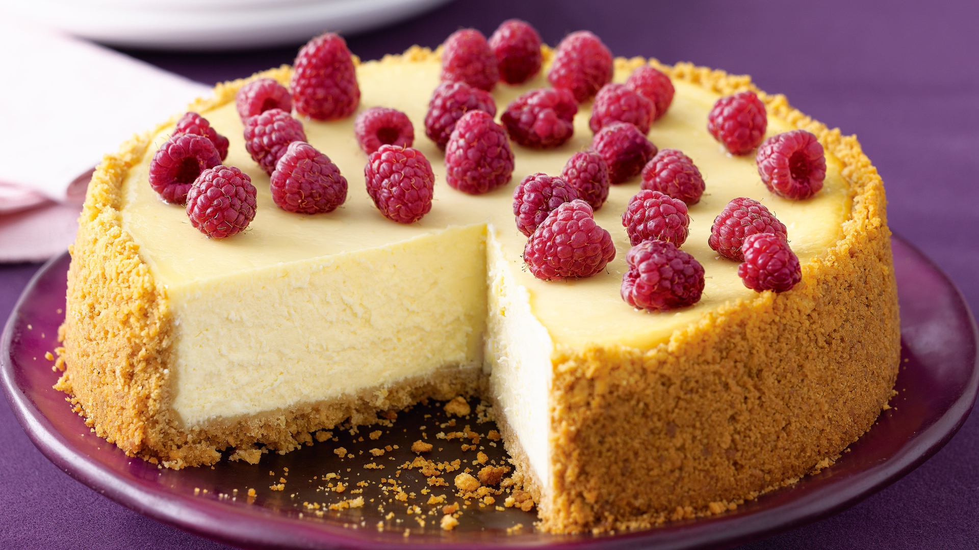 Свежий чизкейк с малиной на тарелке 