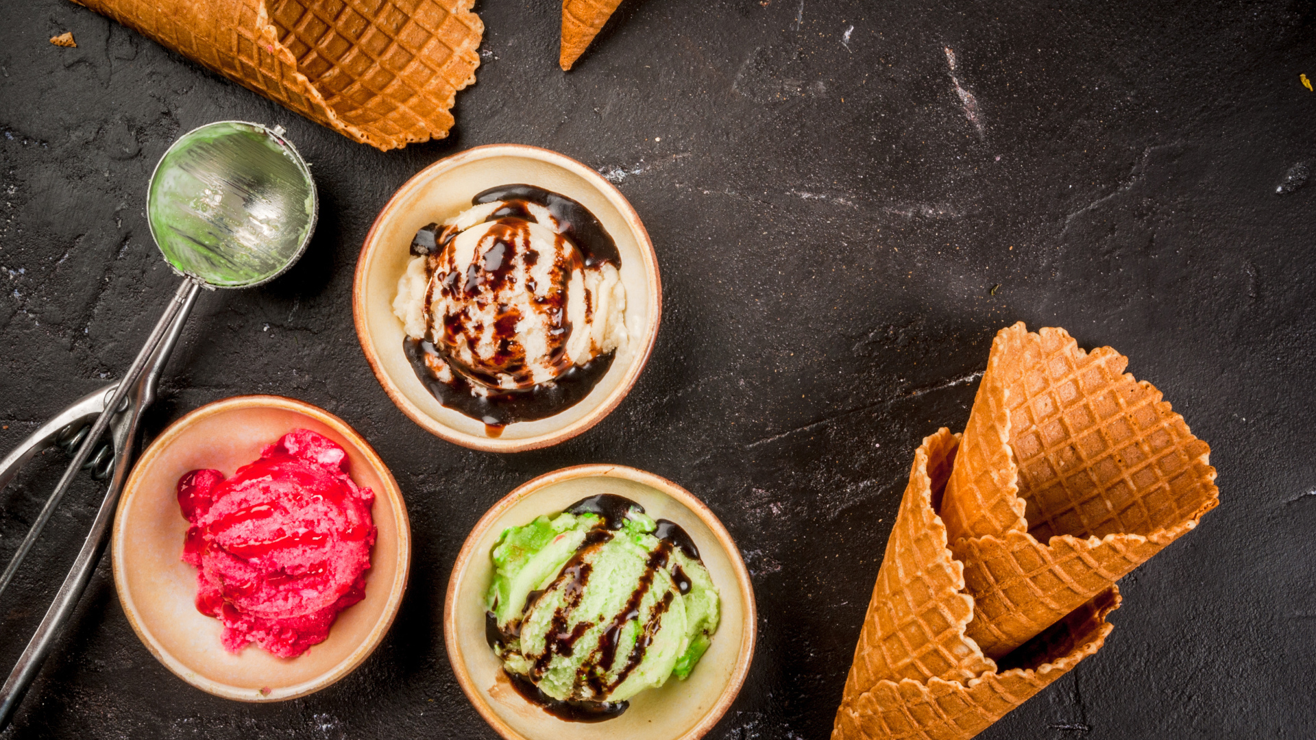 Шарики мороженого с вафельными рожками на столе 