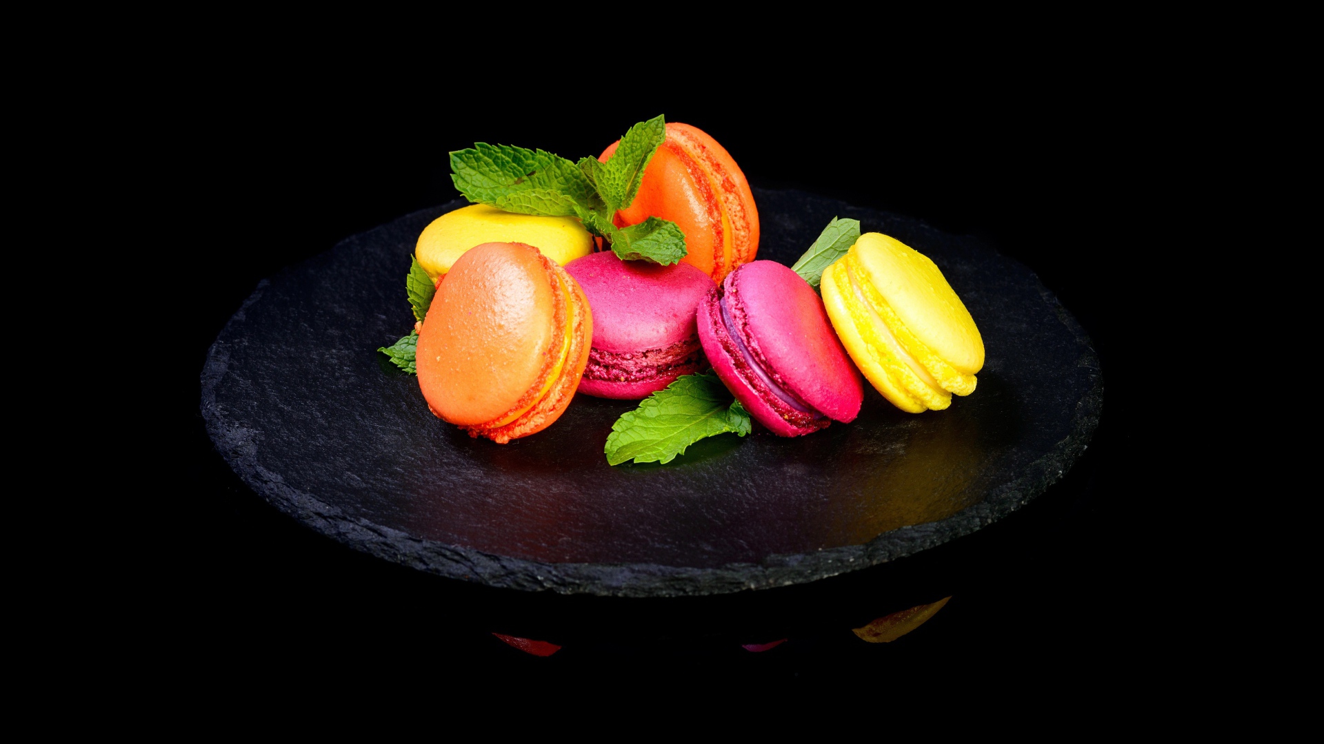 Разноцветный десерт макарон на черном фоне