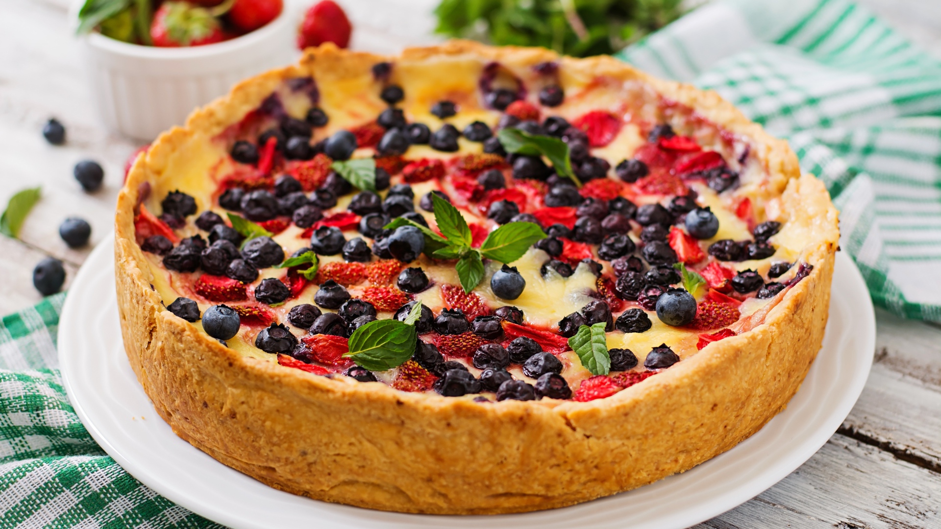 Сладкий пирог с черникой и клубникой на белом блюде