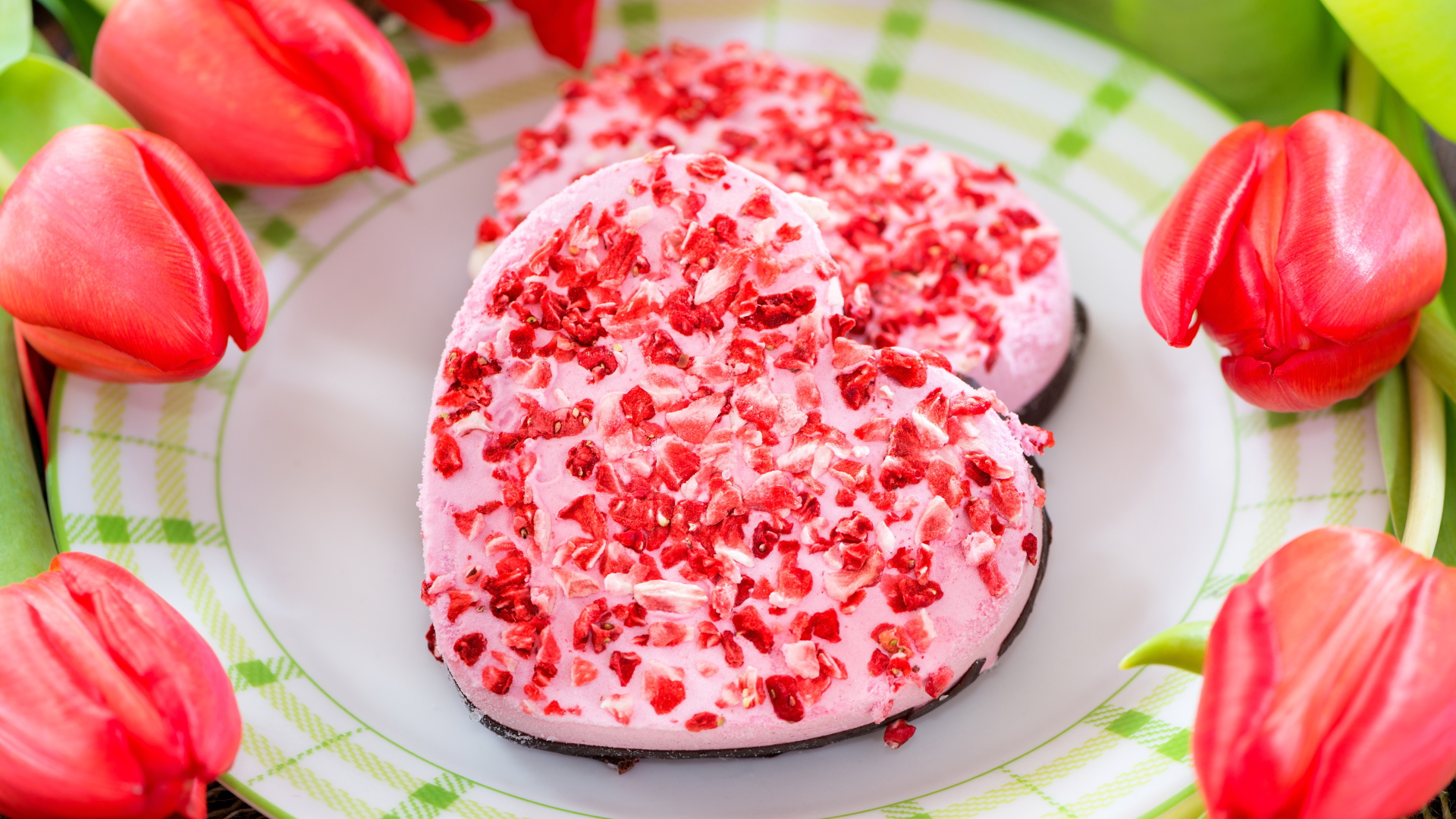 Два печенья в форме сердца на тарелке с тюльпанами 