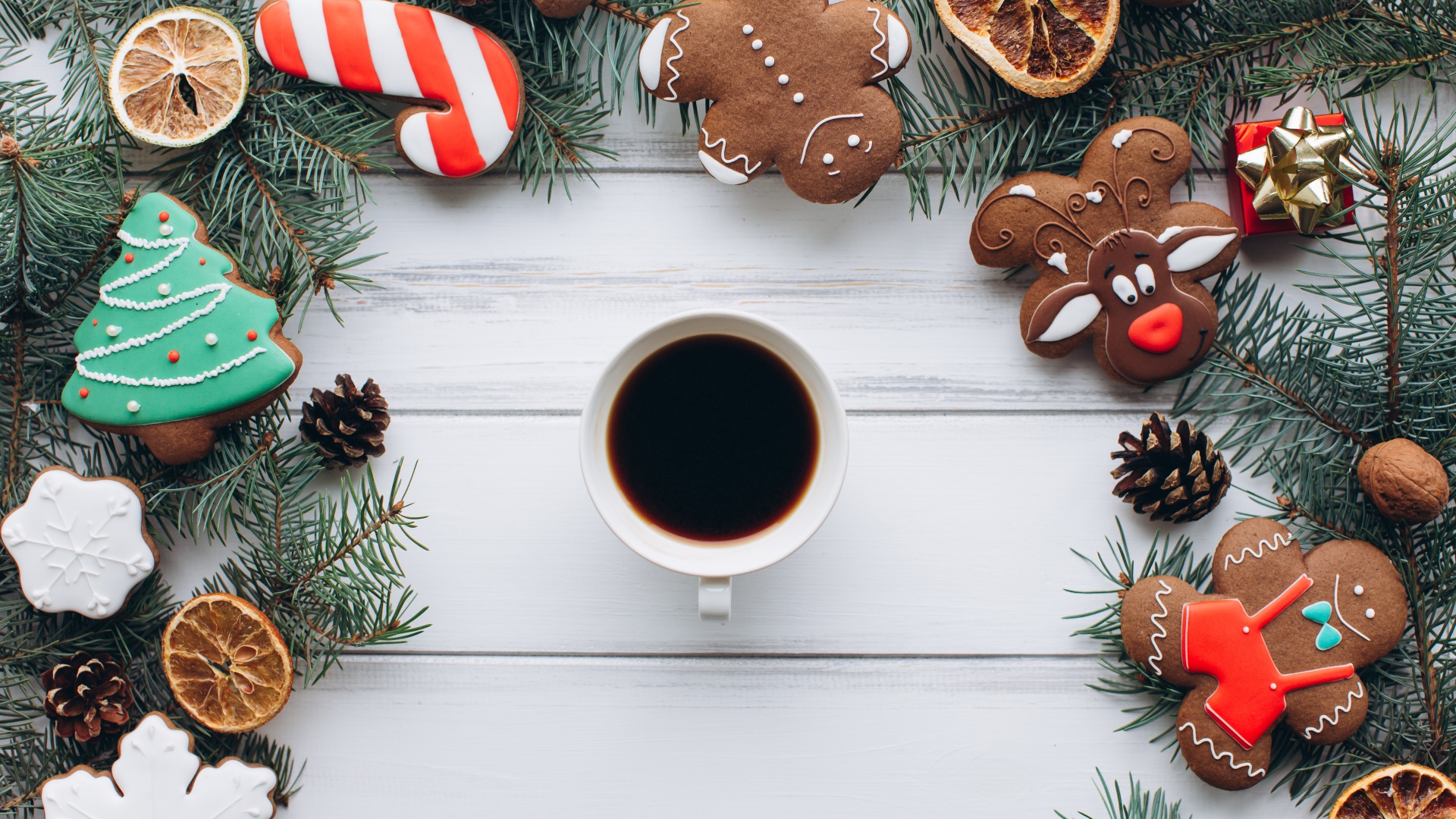 Чашка кофе на деревянном столе с имбирным печенье, еловыми ветками и декором
