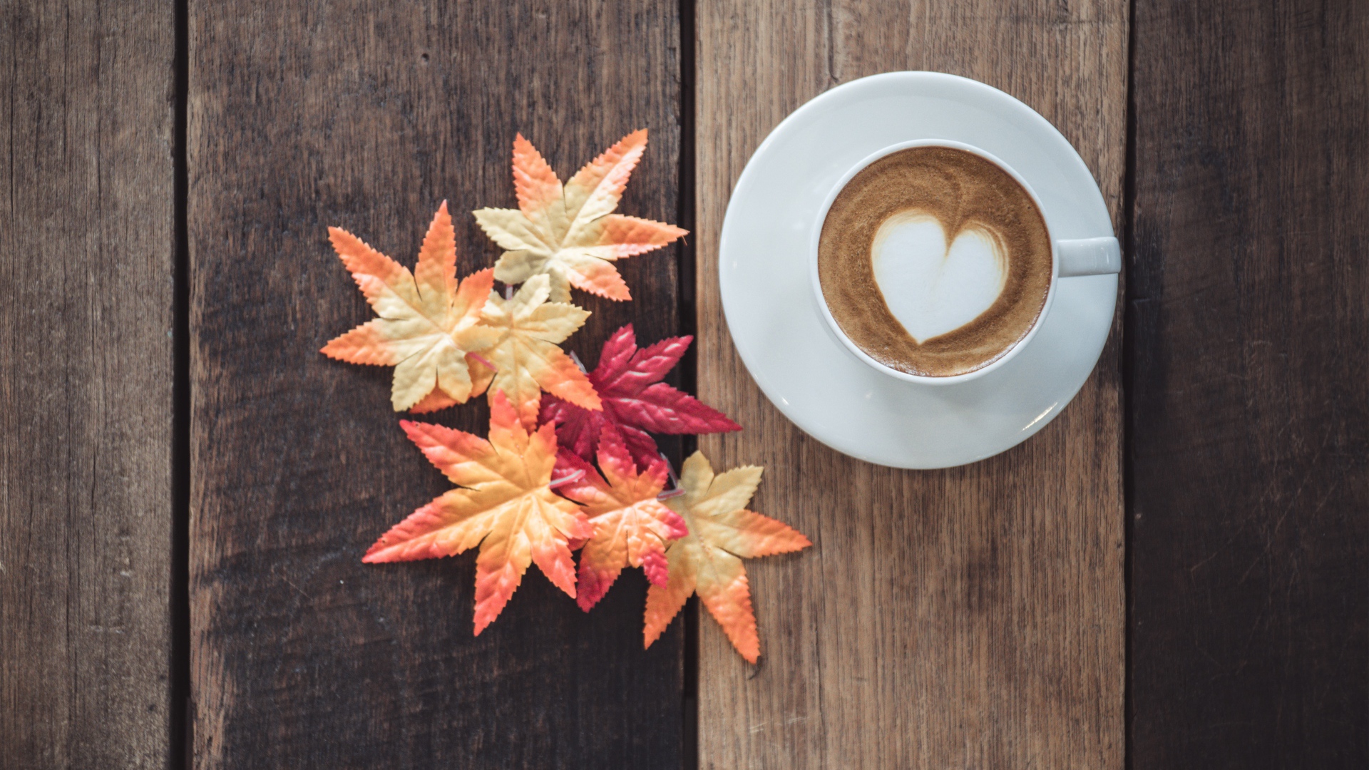 Чашка кофе на деревянном столе с желтыми листьями