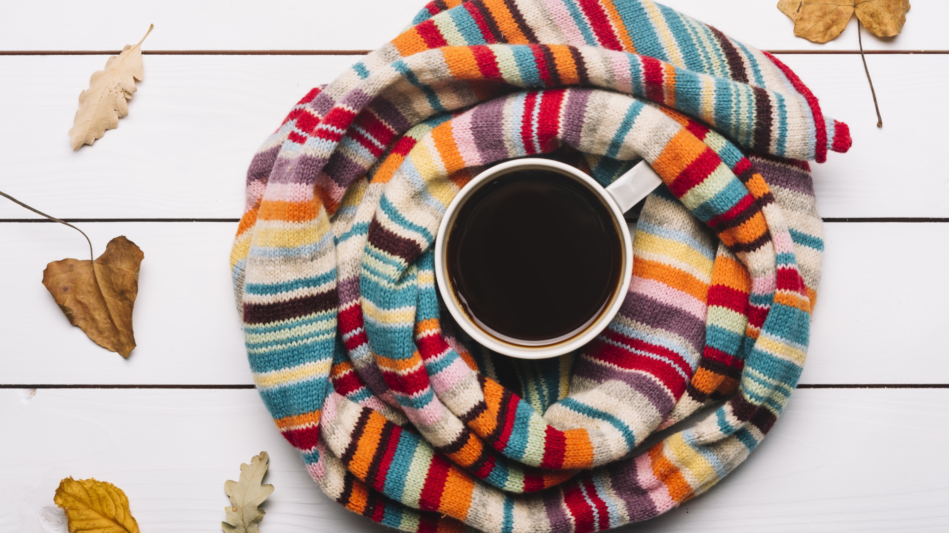 Чашка горячего шоколада на столе с вязаным шарфом
