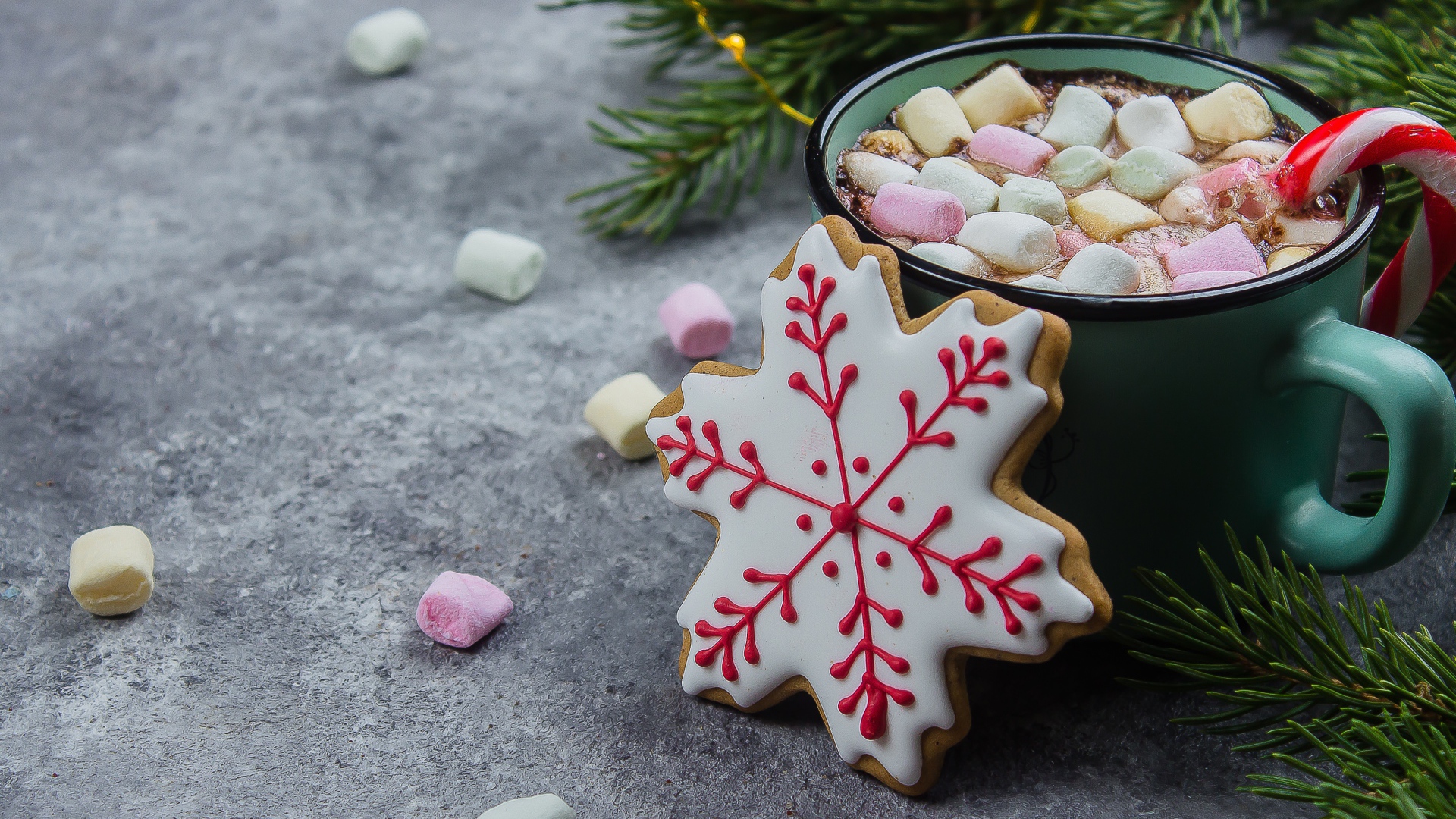 Чашка горячего напитка с кусочками маршмеллоу на столе с печеньем 