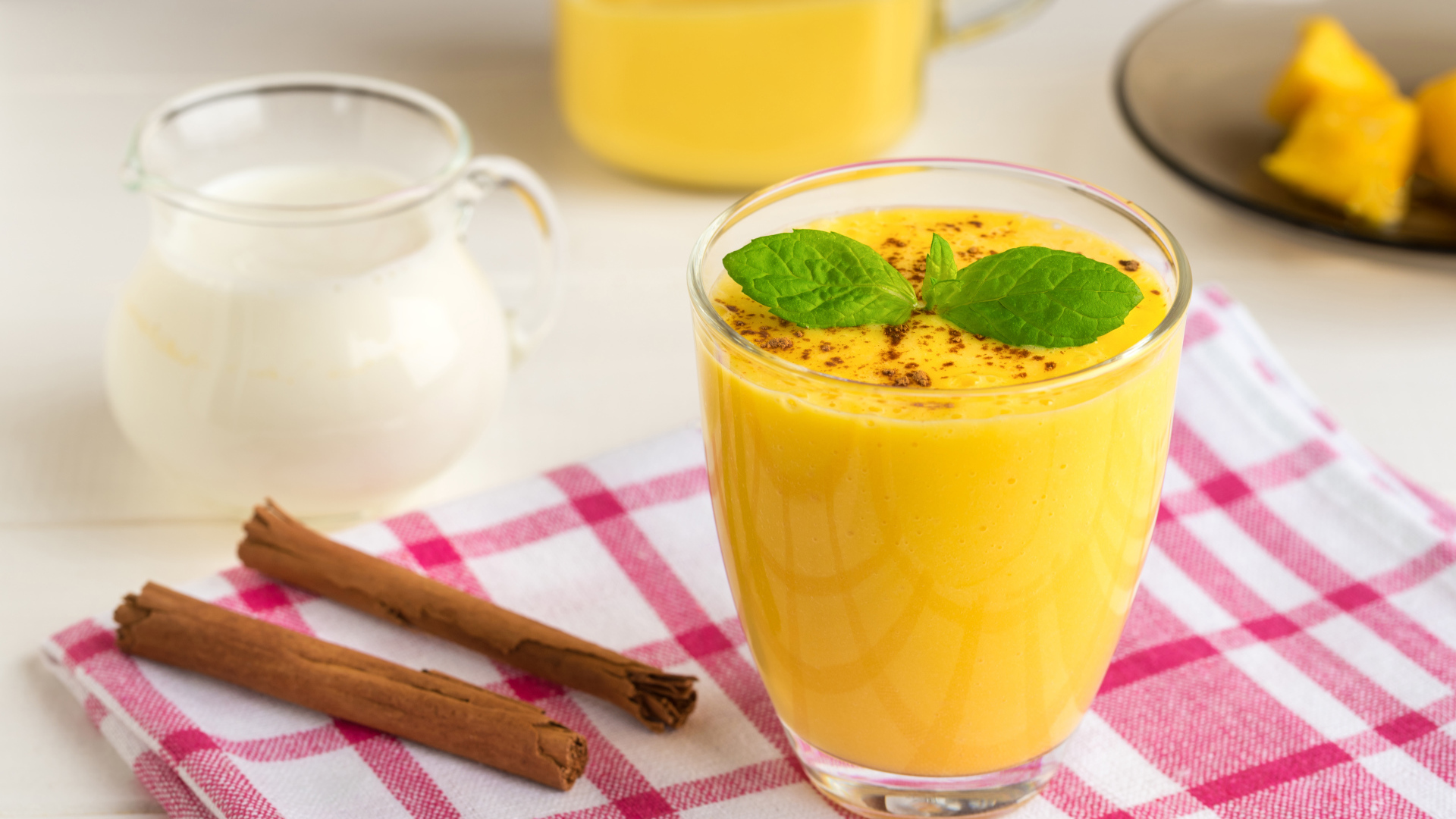 Стакан сока на столе с молоком и корицей