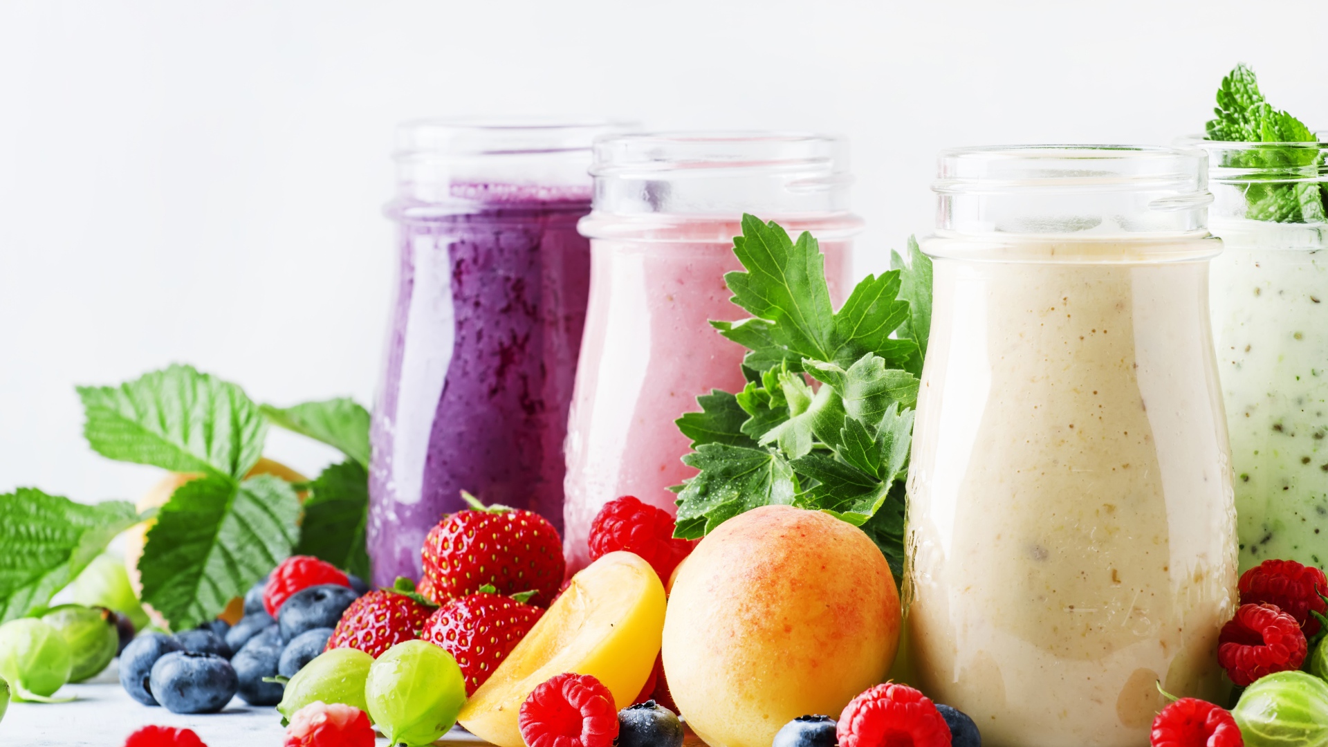 Ягодные смузи в бутылочках на столе с ягодами