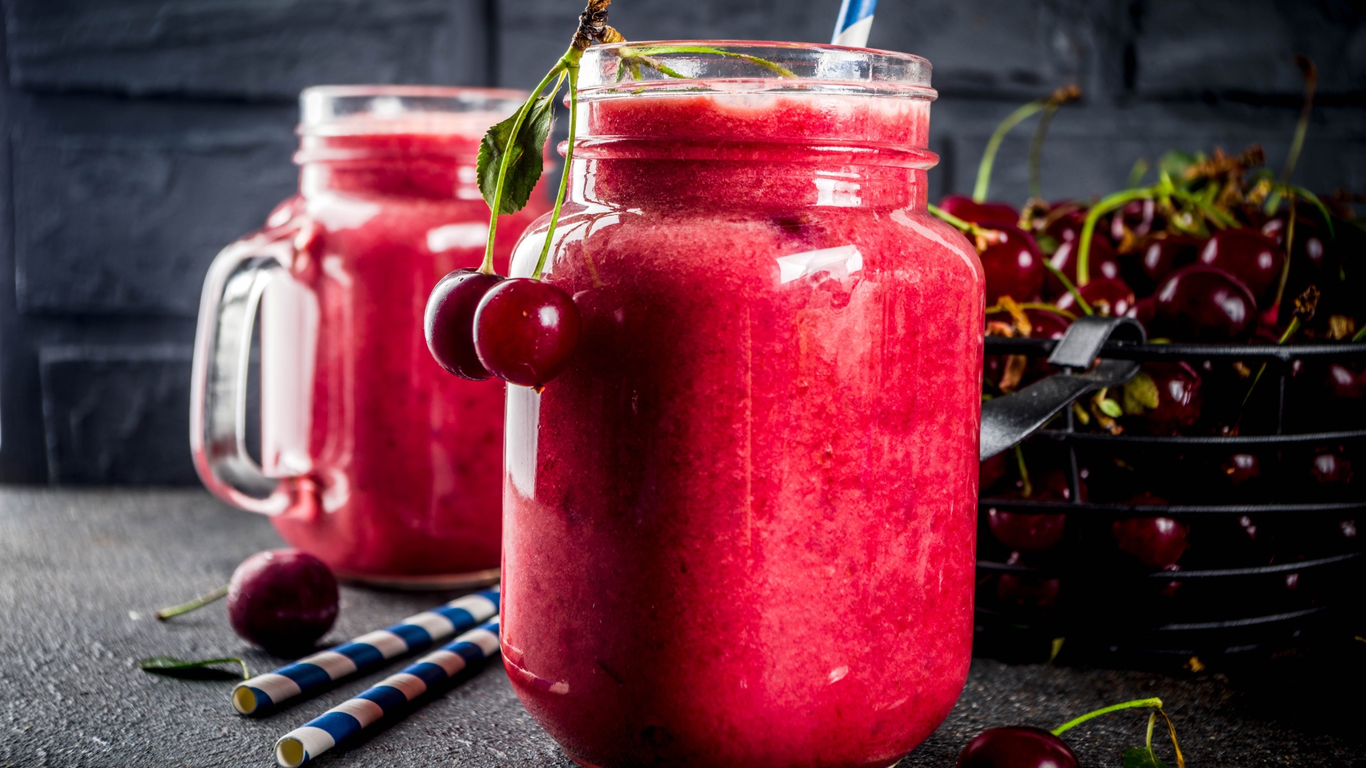 Вишневое смузи в стеклянной банке на столе с ягодами